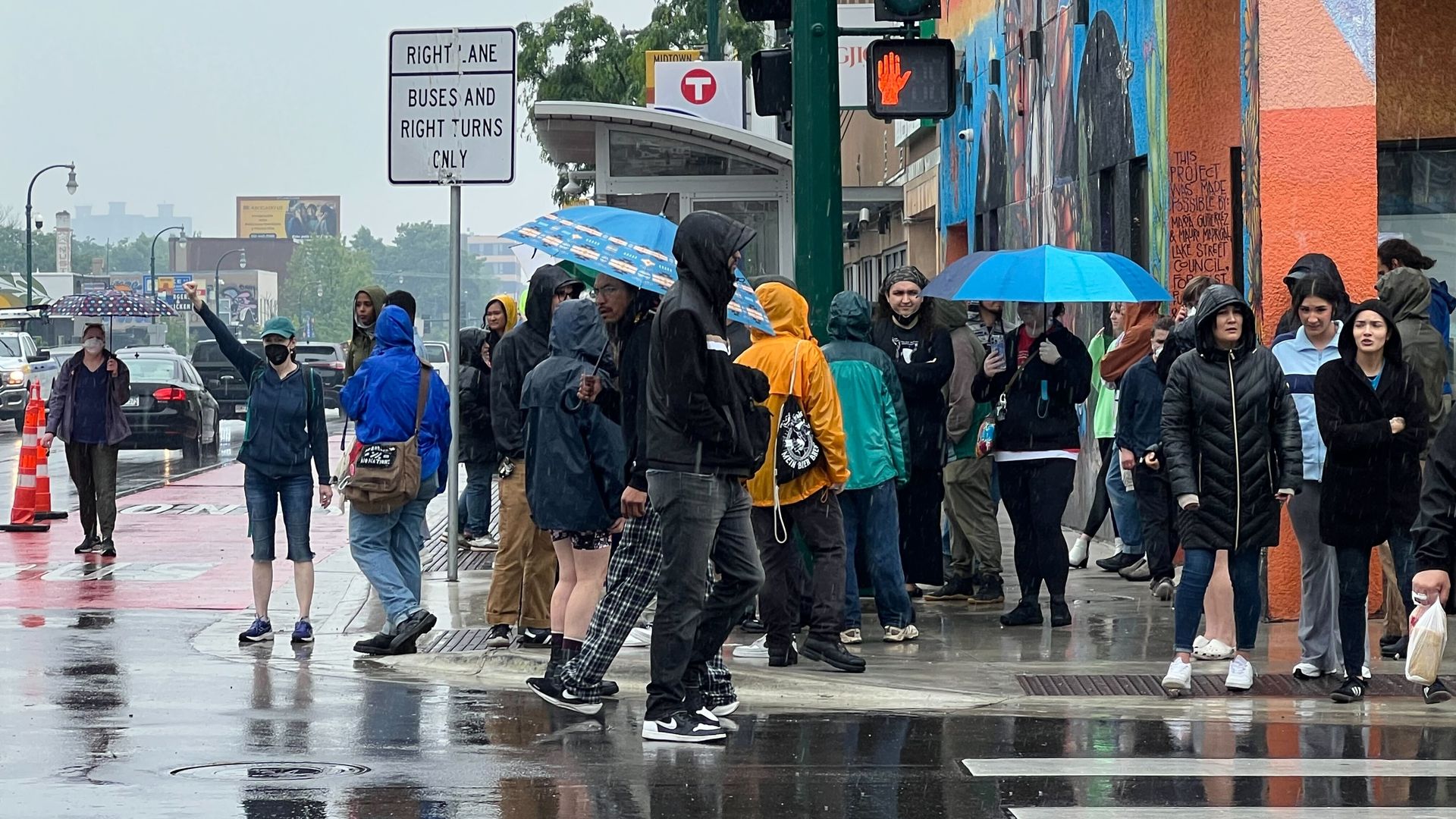 Protestors outside of a restaurant with umbrellas 