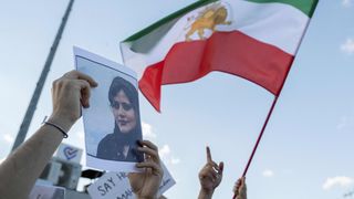 Another protests against the Iranian regime in Istanbul on October 2 holding a picture of Kurdish-Iranian woman Masa Amini, while another waved an old Iranian flag.