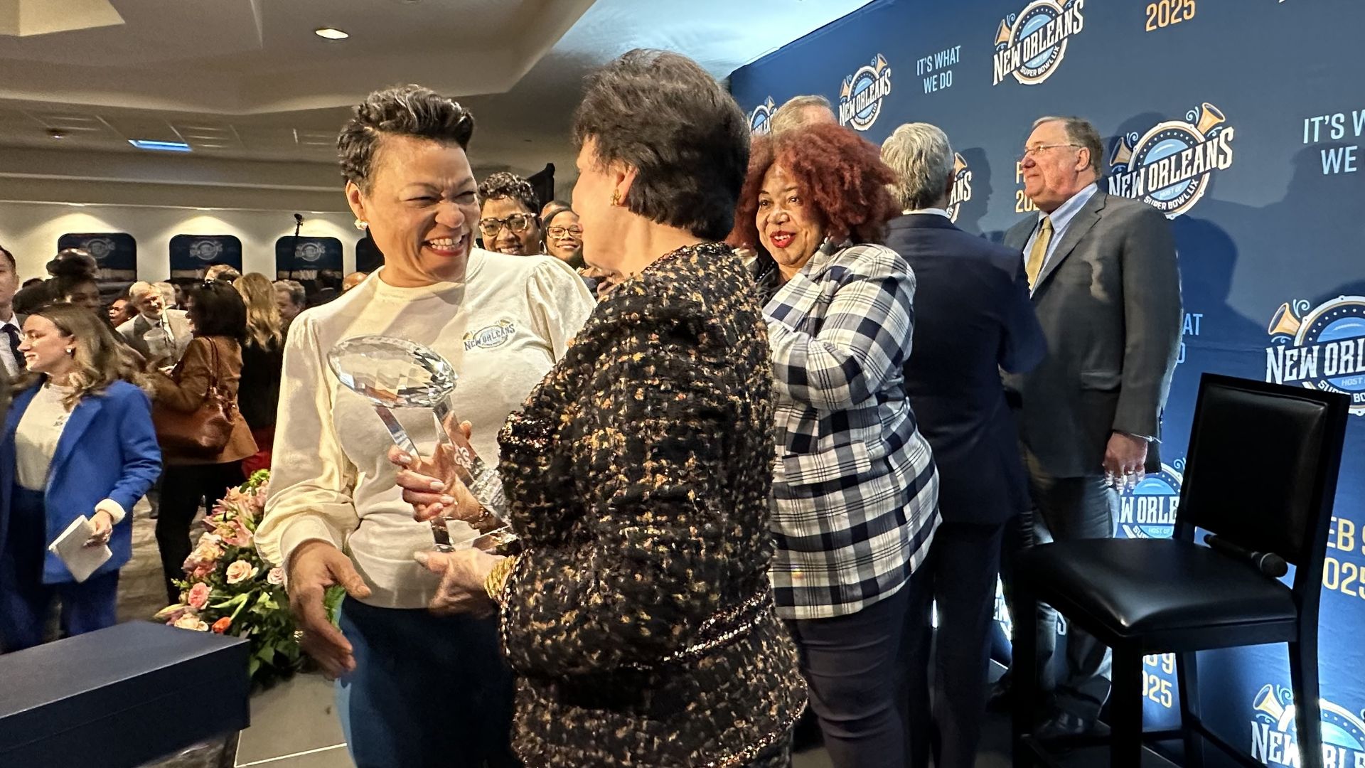 Photo shows Mayor LaToya Cantrell and Saints owner Gayle Benson smiling at each other on stage