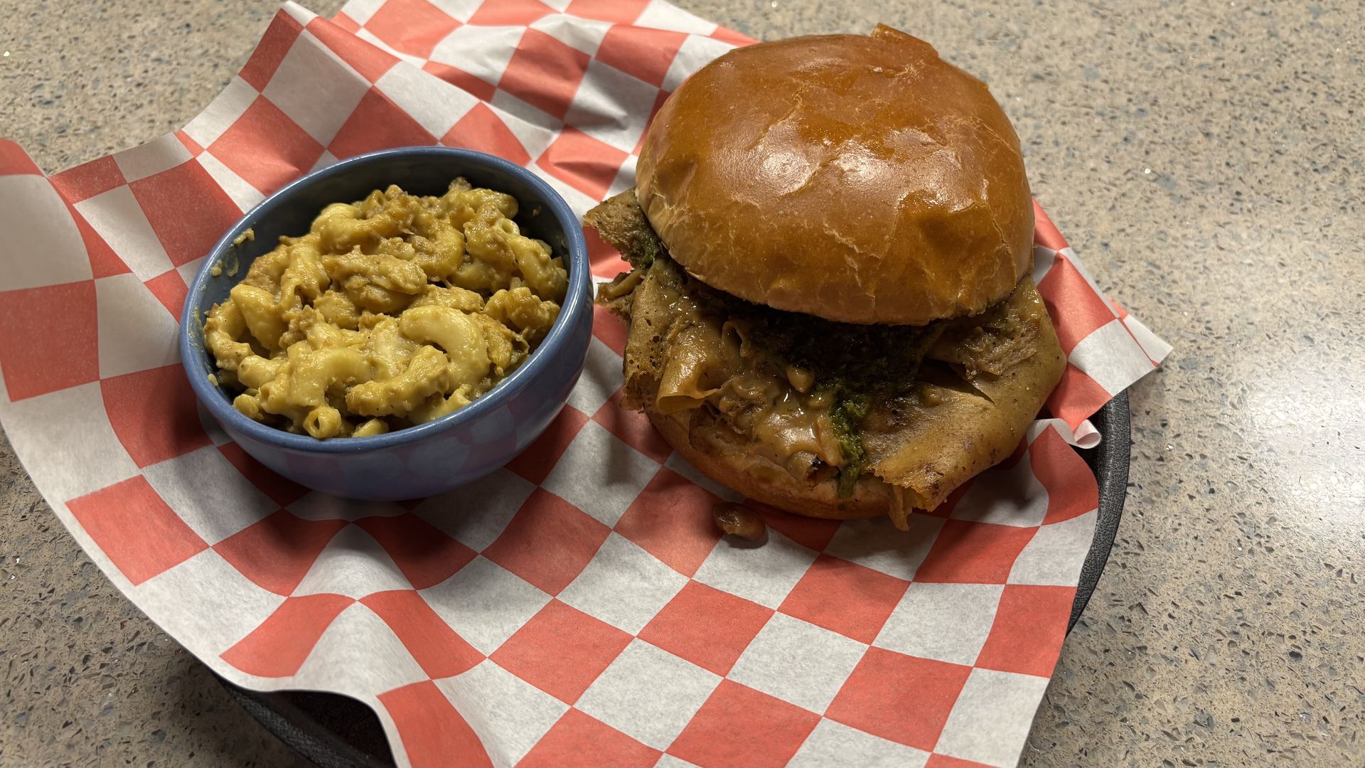 A sandwich and mac and cheese in a basket. 