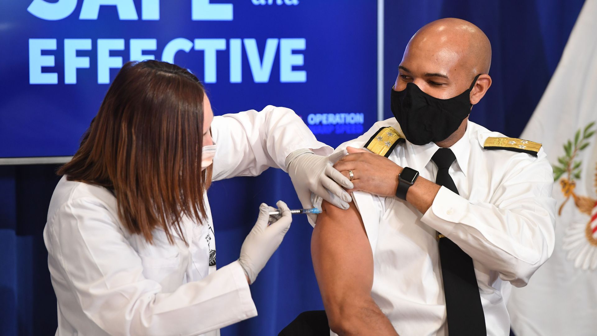 Former U.S. Surgeon General Jerome Adams gets a COVID-19 vaccine.