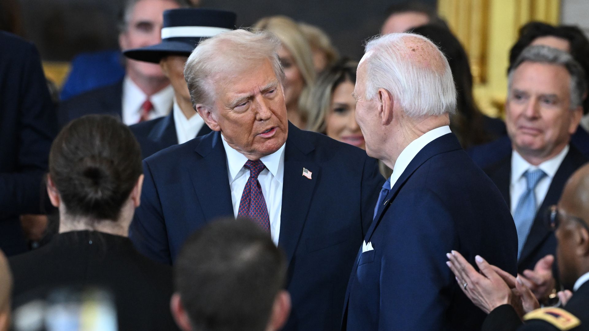 President Trump talks as Biden listens with a crowd around them