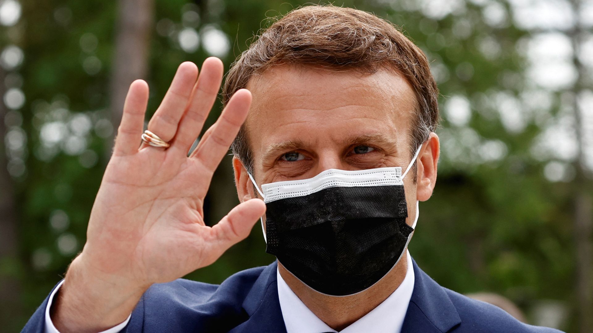 Emmanuel Macron, wearing a mask, waves as he visits a polling station in Le Touquet, during the first round of the French regional elections on June 20, 2021