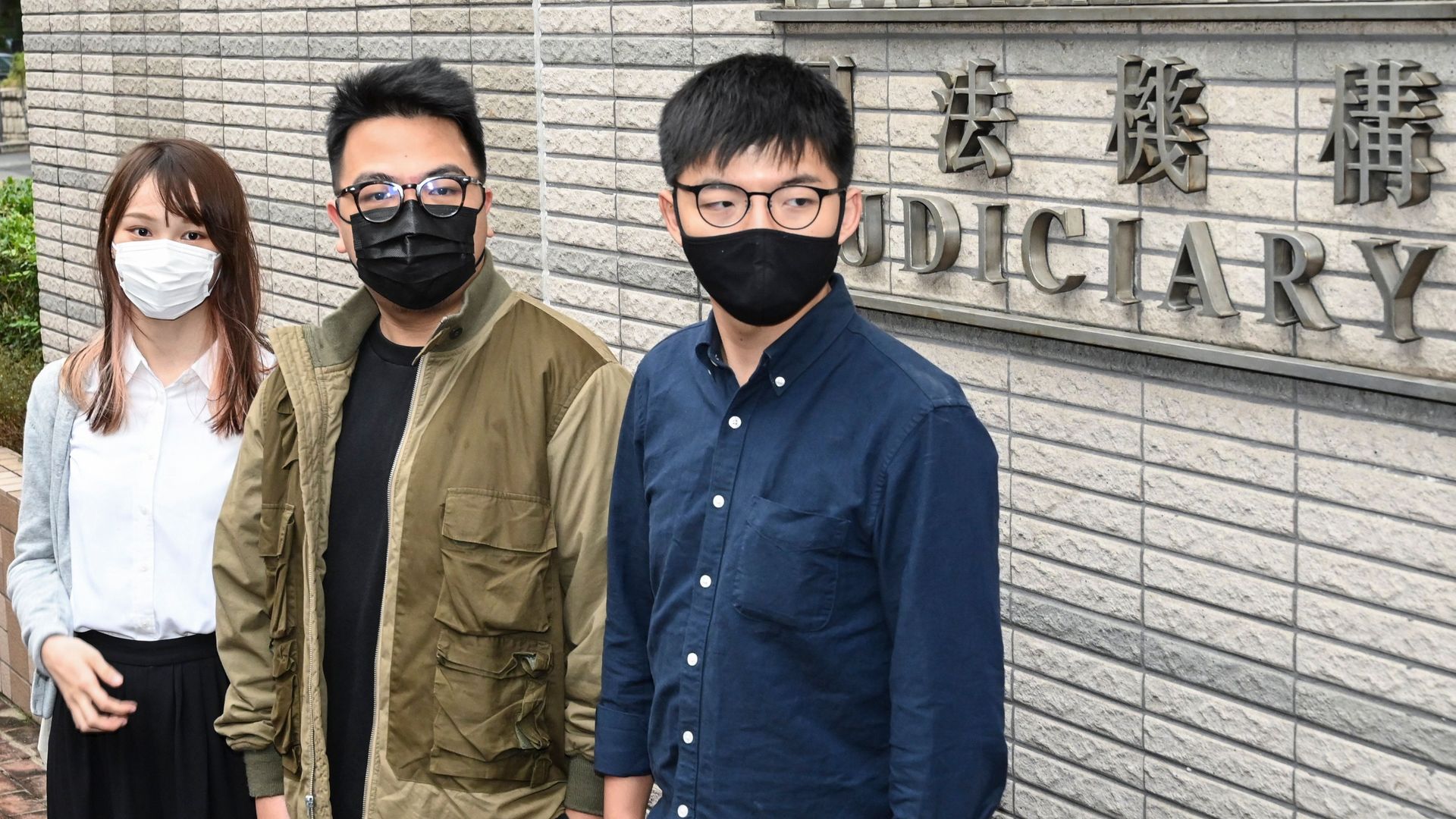 Pro-democracy activists (L-R) Agnes Chow, Ivan Lam and Joshua Wong arrive for their trial at West Kowloon Magistrates Court in Hong Kong on November 23