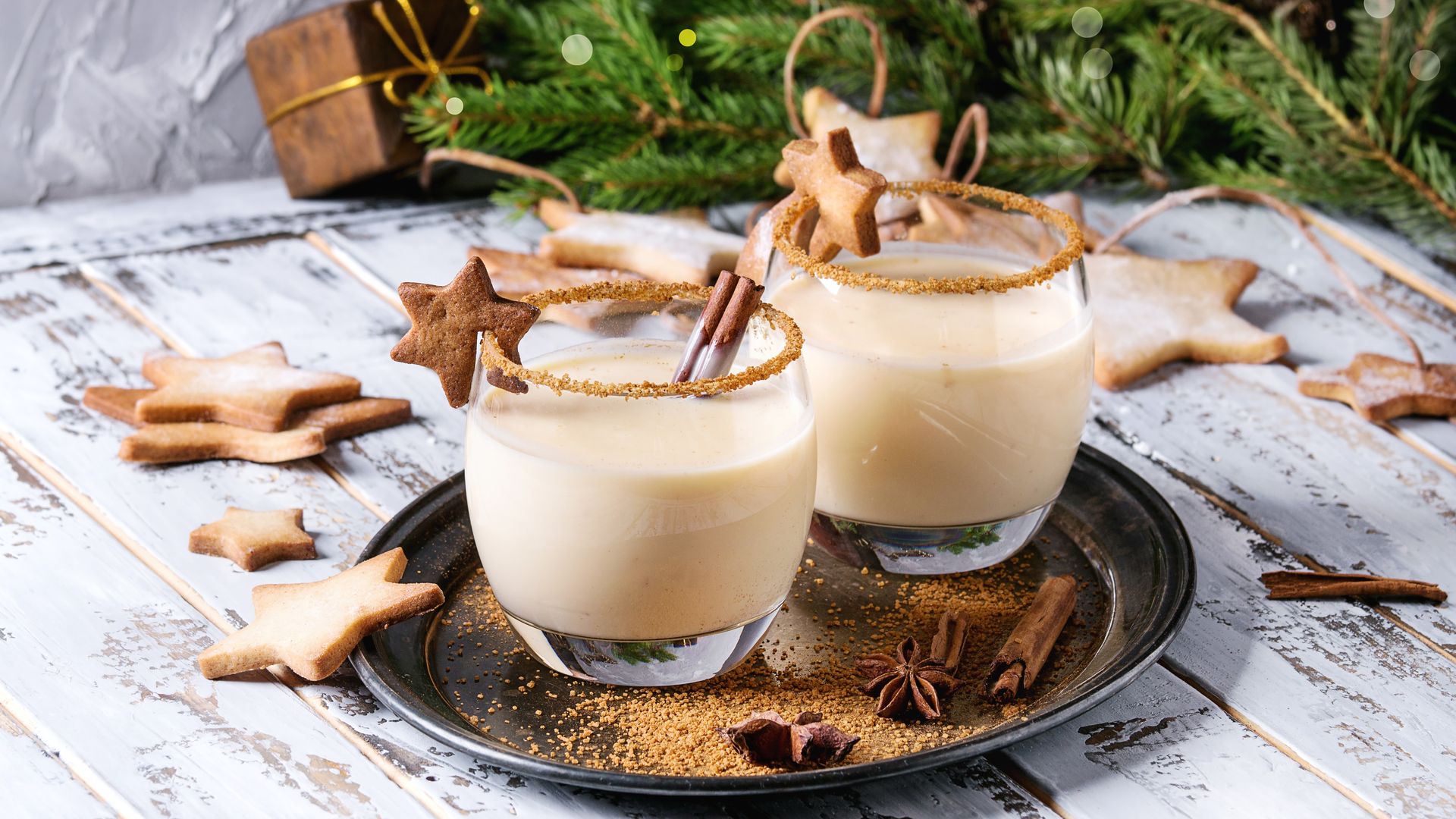Glasses of eggnog surrounded by gingerbread cookies