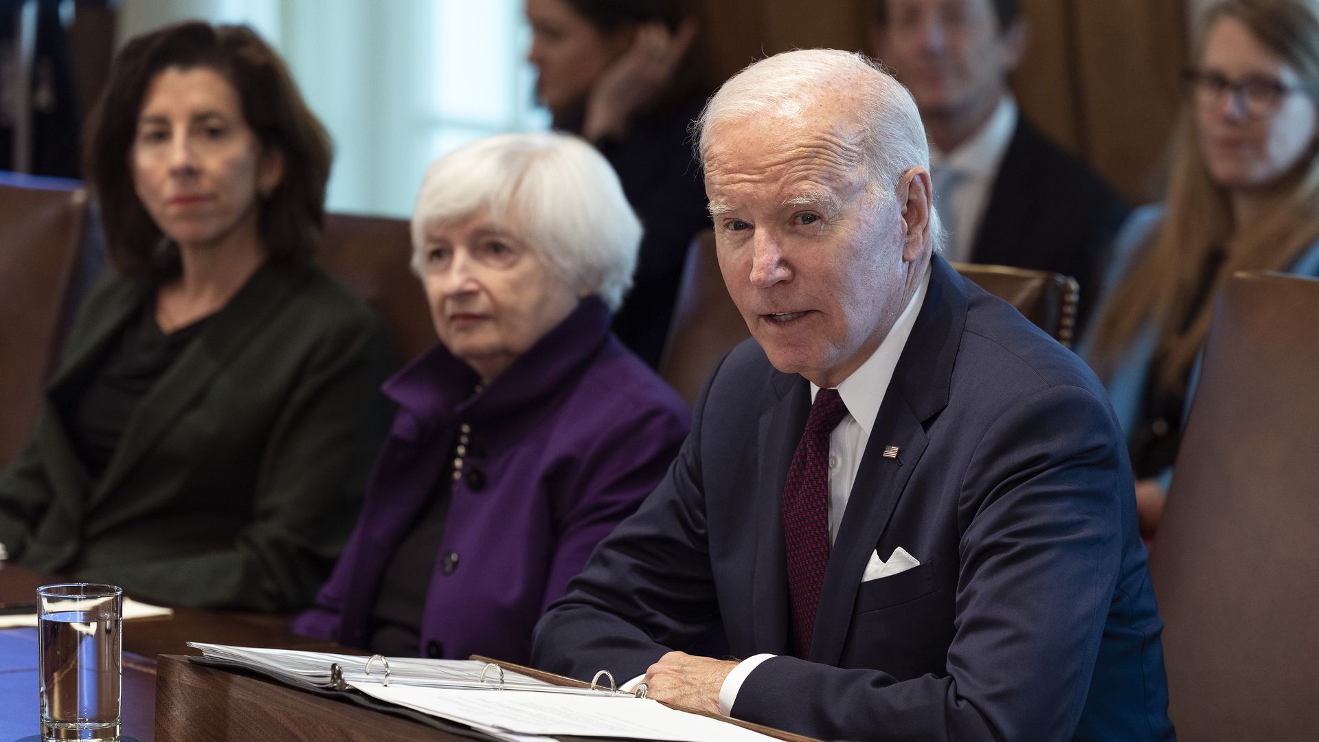 President Biden sits at a table at a Cabinet meeting with Treasury Secretary Janet Yellen (middle) and Commerce Secretary Gina Raimondo (right).