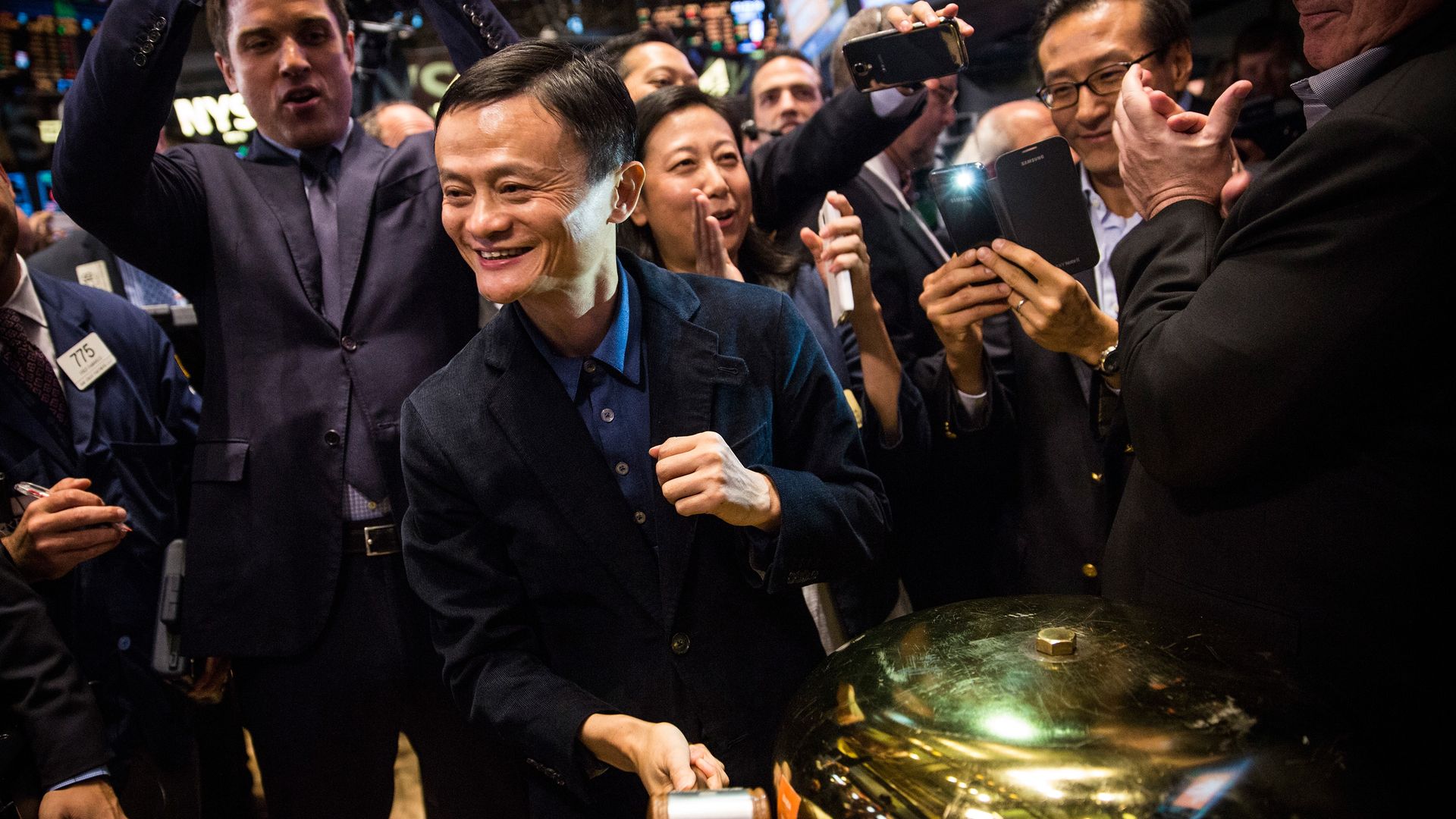 Jack Ma rings a bell, surrounded by cheering people
