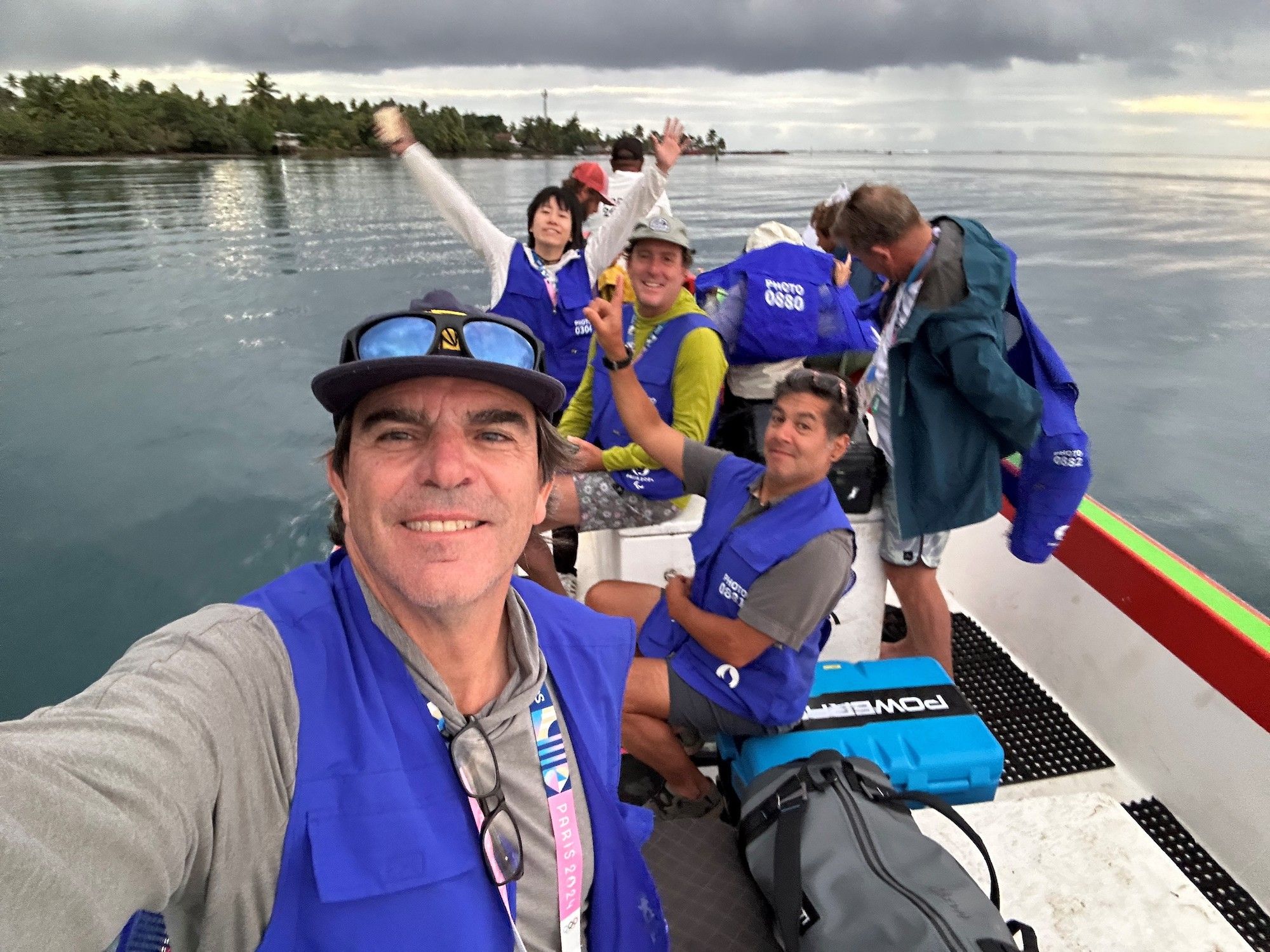 A photographer takes a selfie with others on a boat.