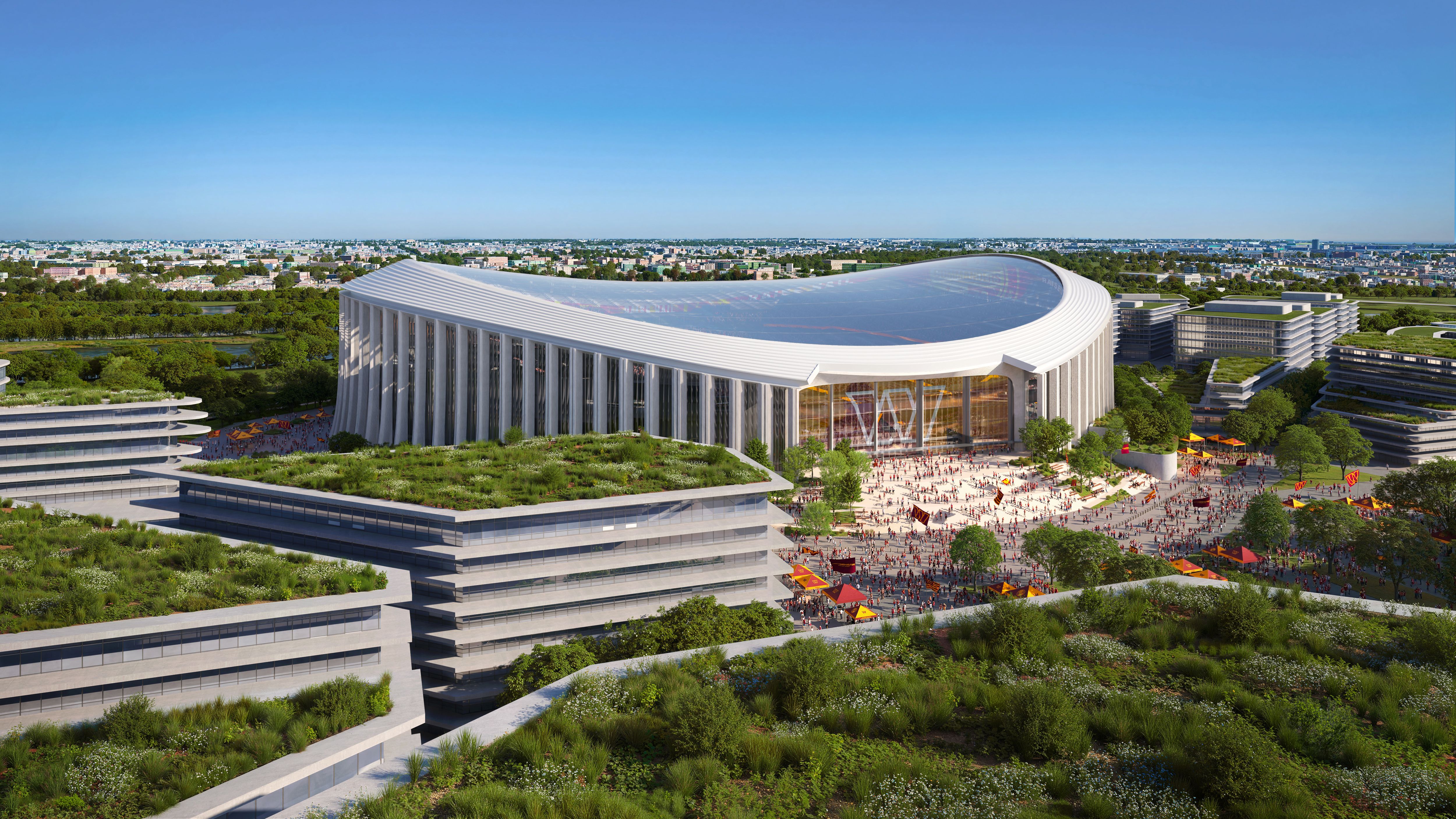 Aerial view of a modern stadium with a wavy glass roof, surrounded by buildings with green rooftops and trees, set against a clear blue sky with crowds around the stadium entrance.