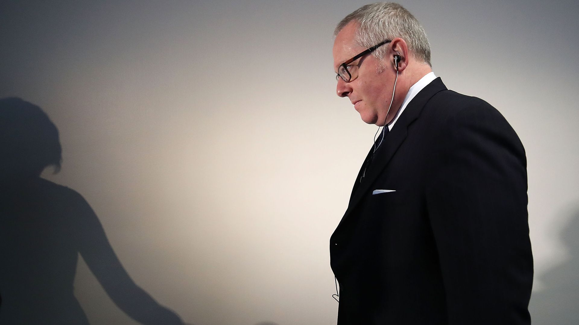 Michael Caputo stands in a suit and walks down a hallway