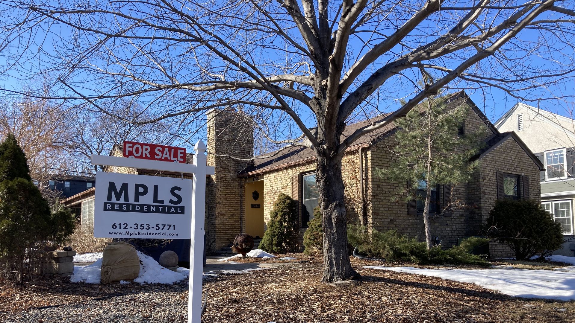 A for sale sign outside of a brick Minneapolis house. 