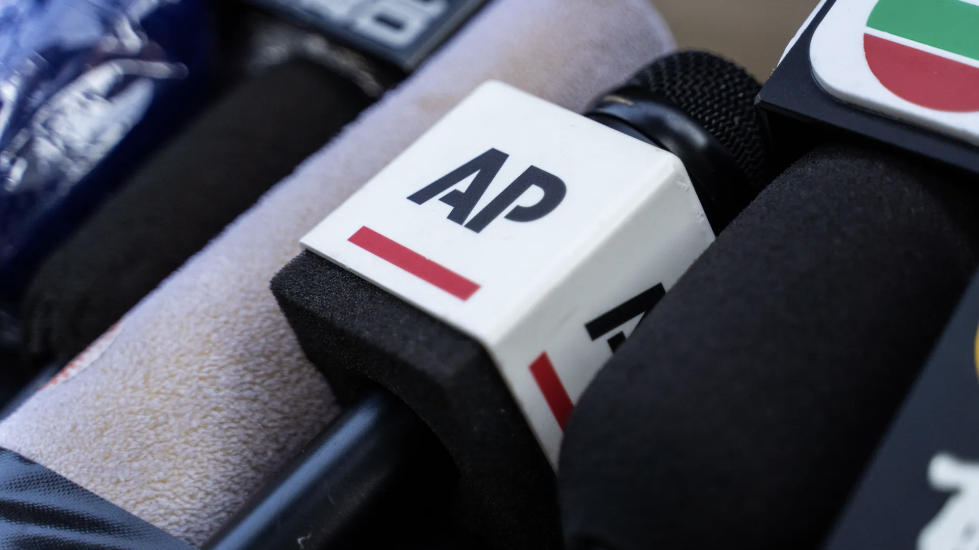 A microphone of the Associated Press, an American non-profit news agency, sits among others.
