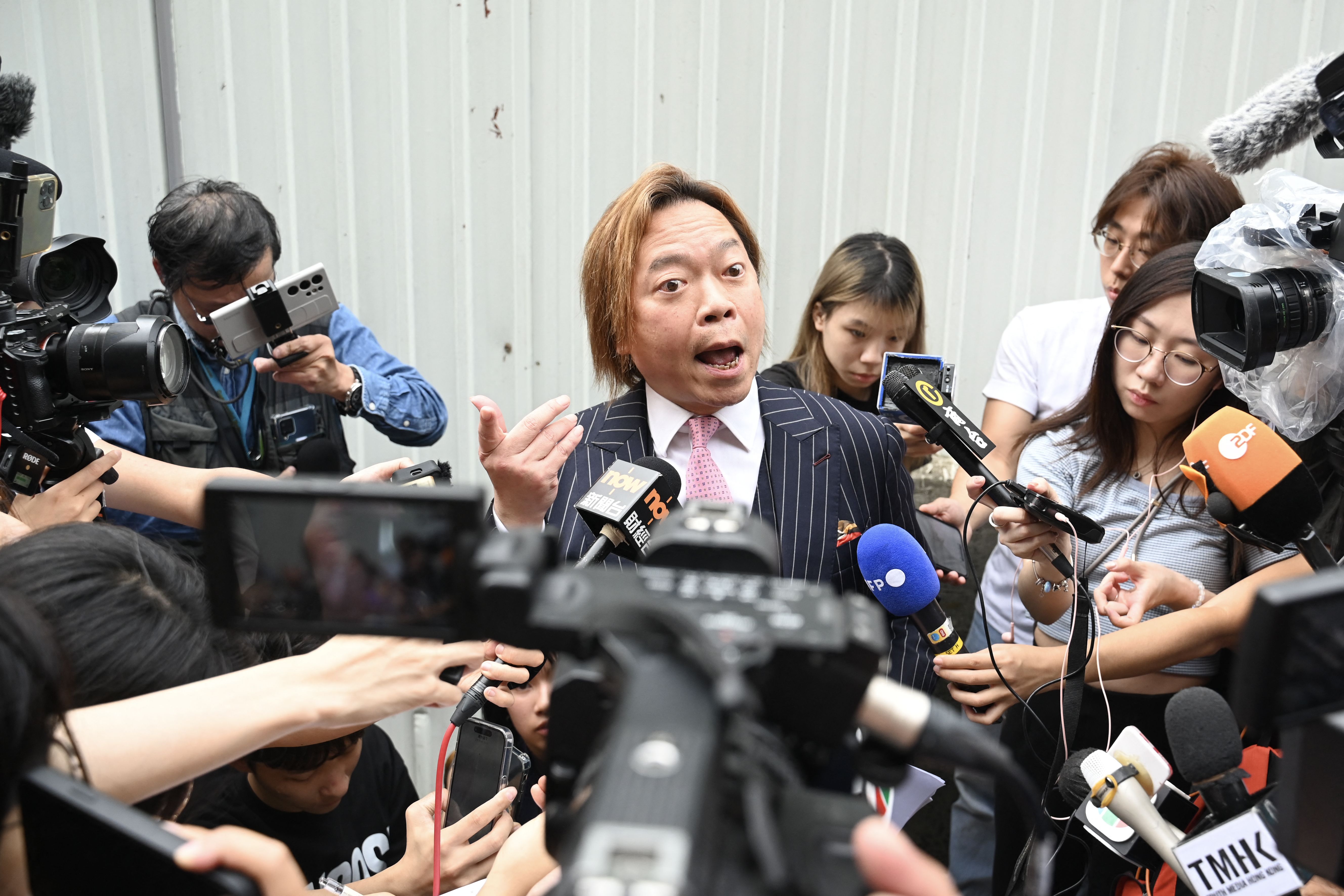 Hong Kong activist Lawrence Lau (C) talks to the media after being found not guilty