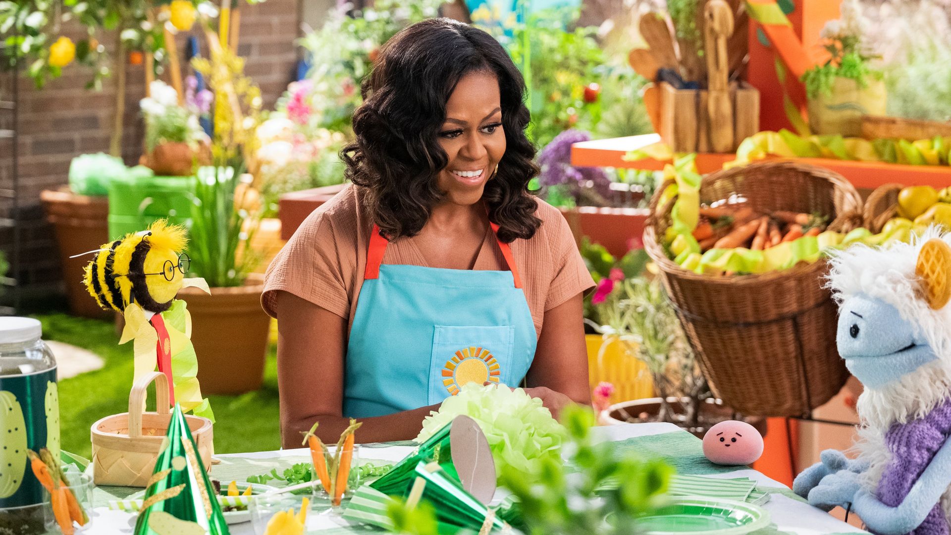 A photo of Michele Obama interacting with puppets on her new Netflix show