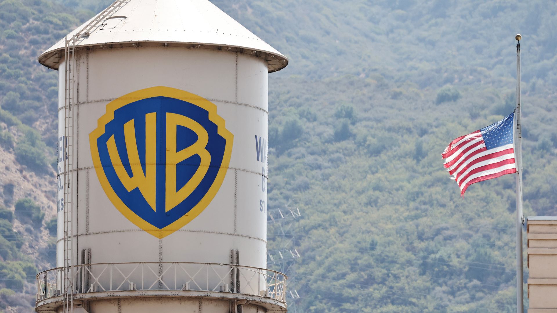 A water tower with the Warner Bros logo and an American flag.