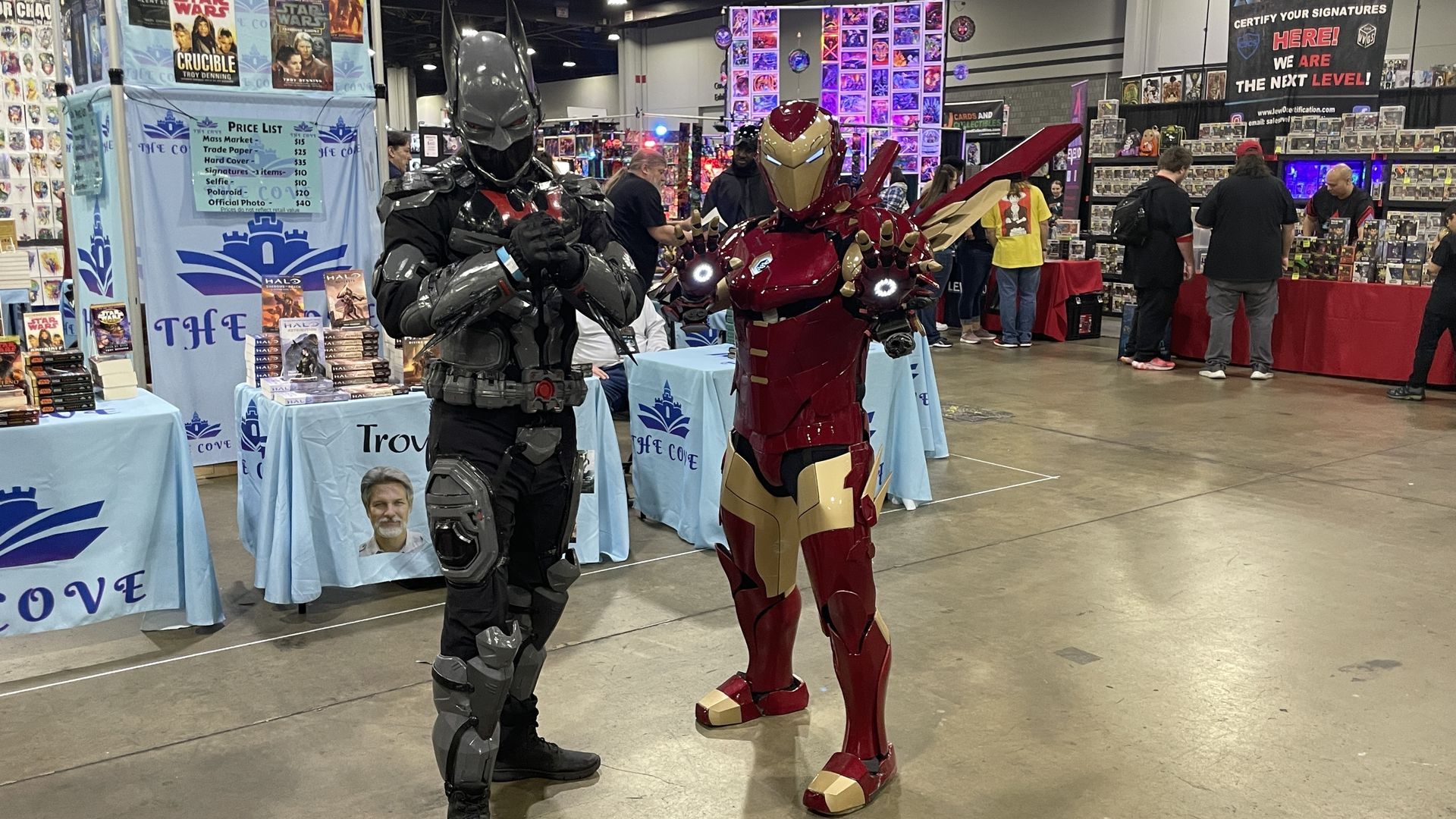 Photo of two men in cosplay, the man to the left is wearing the armored "Hellbat" Batman suit and the man on the right is wearing the Iron Man suit.
