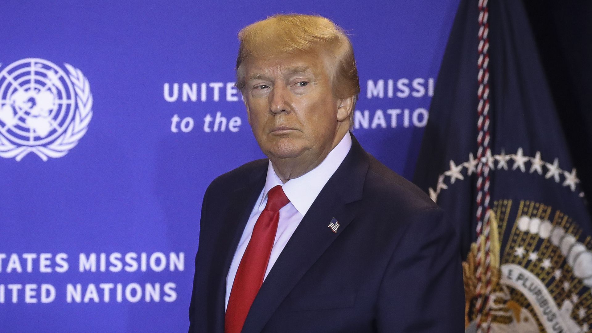 Trump standing and staring to his left.