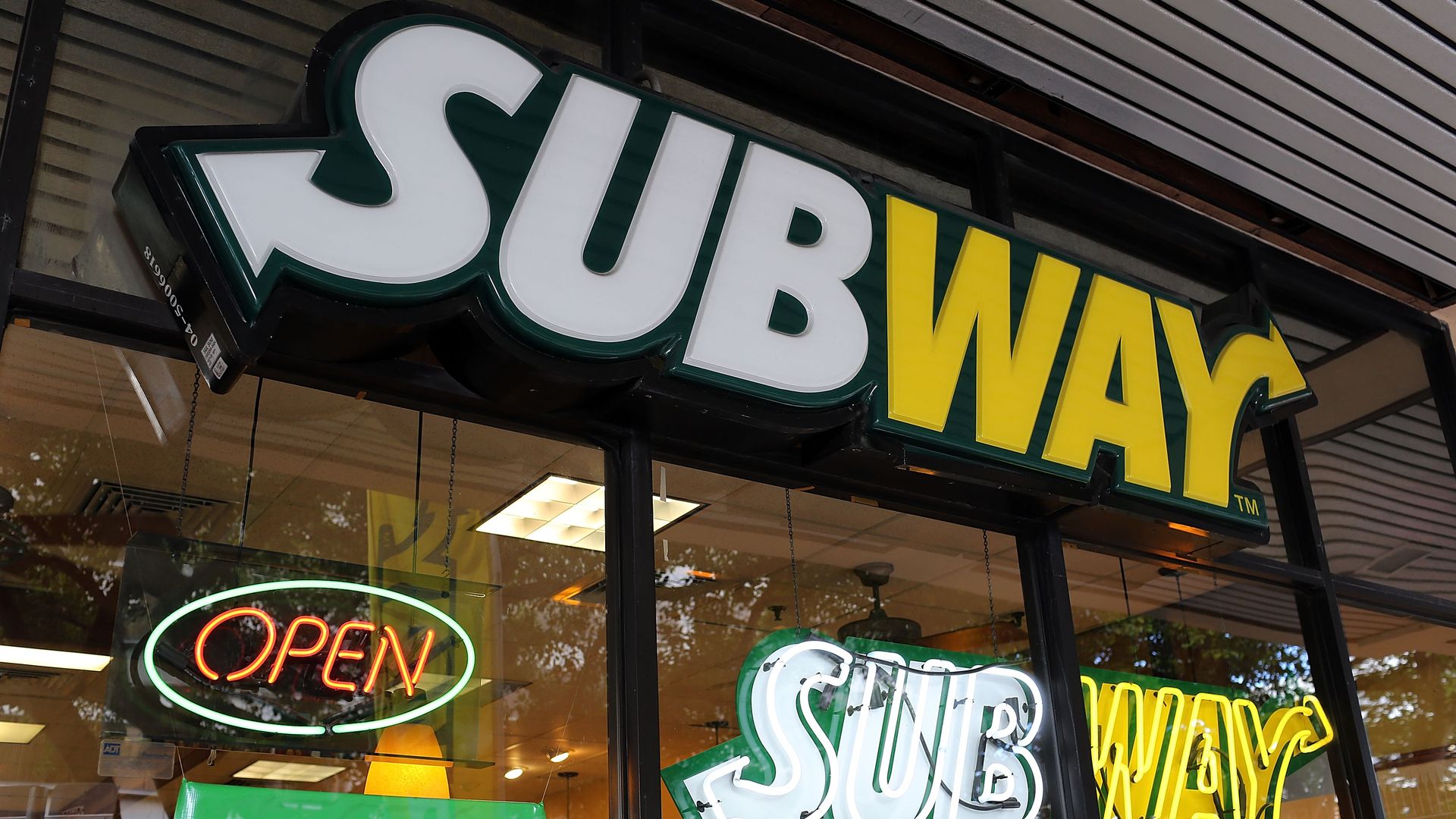 Subway restaurant storefront with signs saying Subway and an open sign