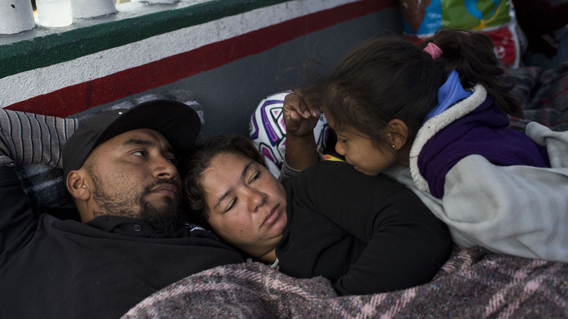 An immigrant family resting while en route from Central America to the U.S. border