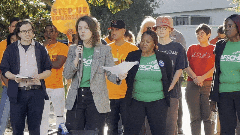 Image shows people wearing union shirts and talking with a microphone.