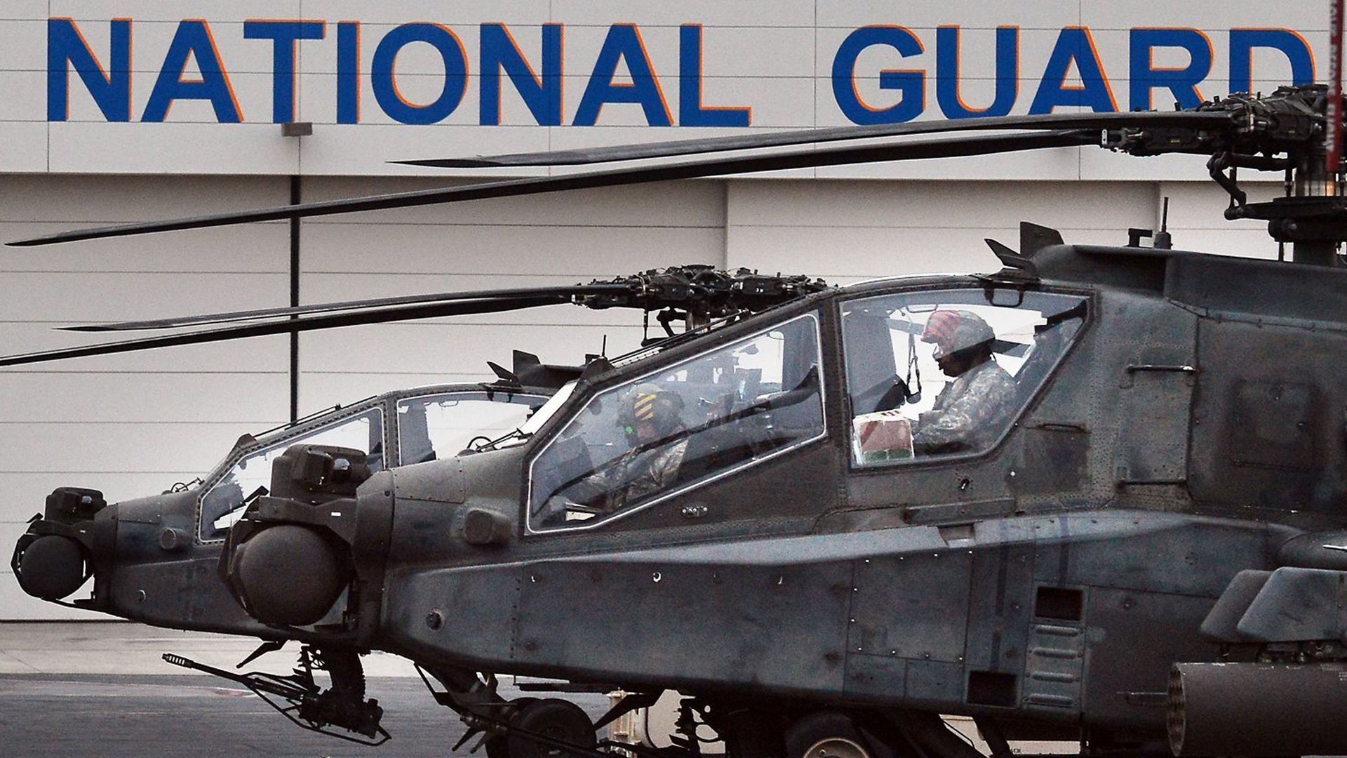 Two helicopters sit on the tarmac