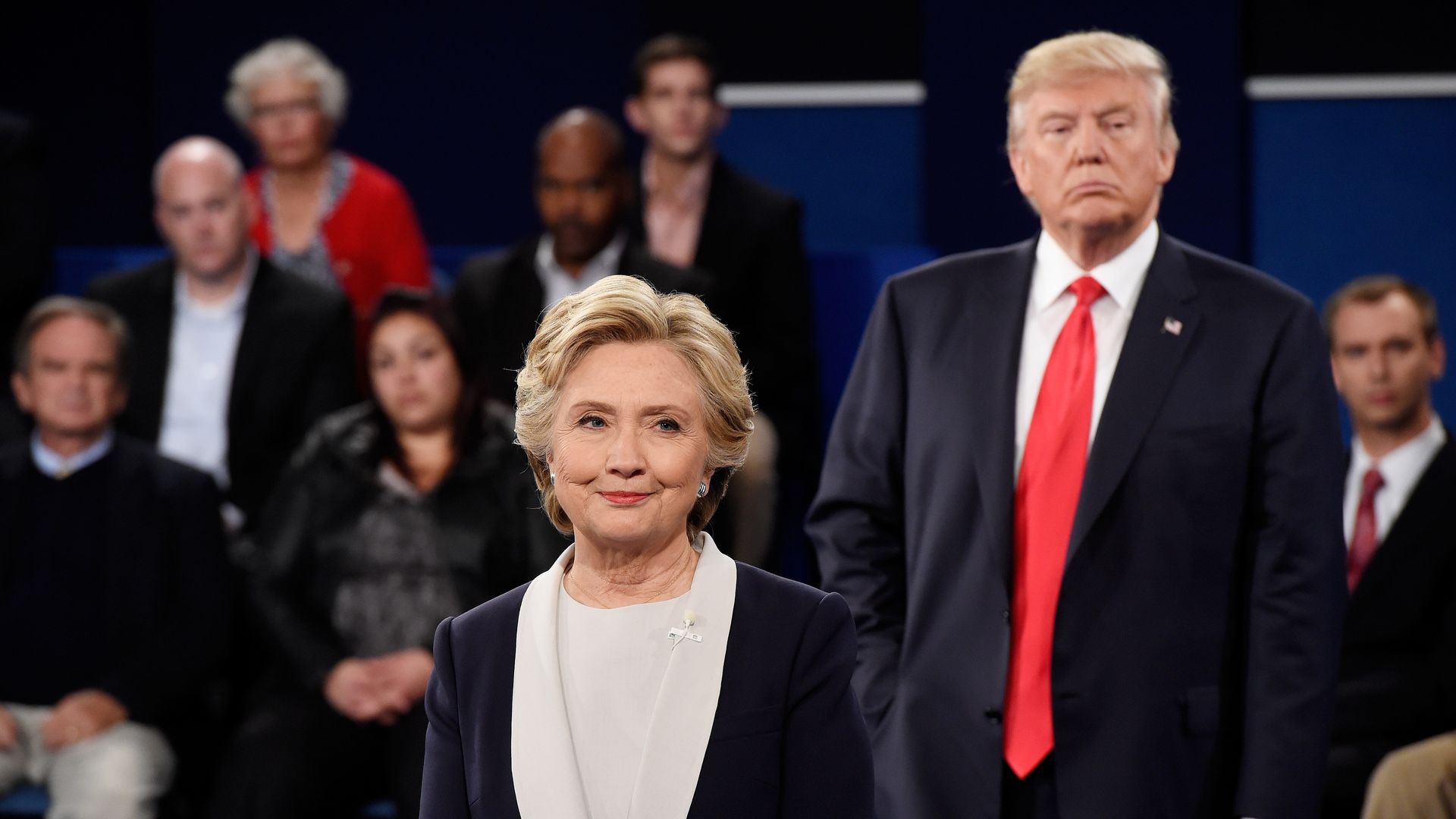 Hillary Clinton (L) and Donald Trump listen during the town hall debate at Washington University on October 9, 2016 in St Louis, Missouri. 