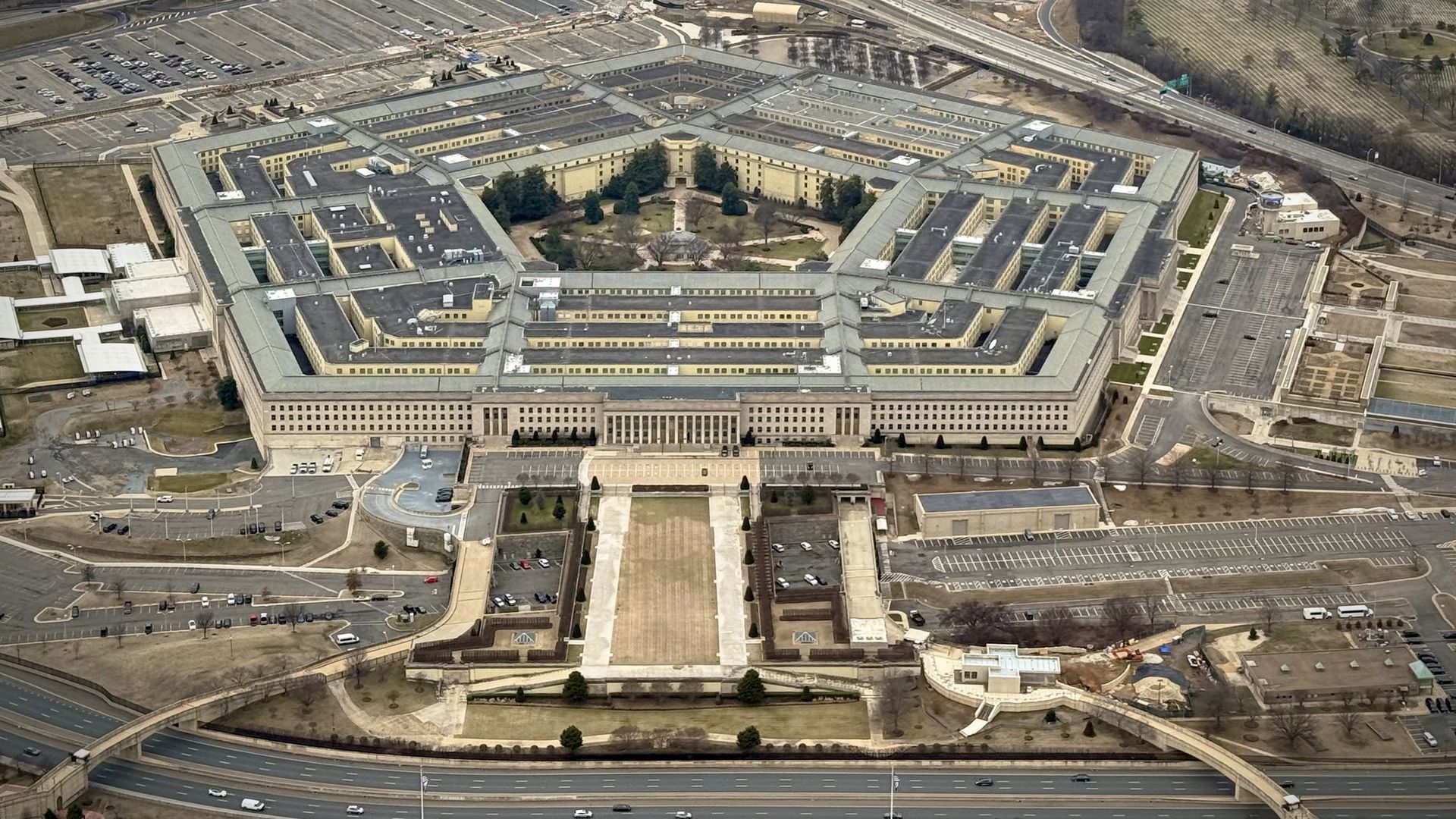 An aerial view of the Pentagon, surrounded by roads, cars, parking lots and construction.