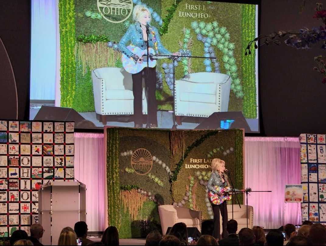 Dolly Parton singing at a charity luncheon at the Ohio State University ballroom. 