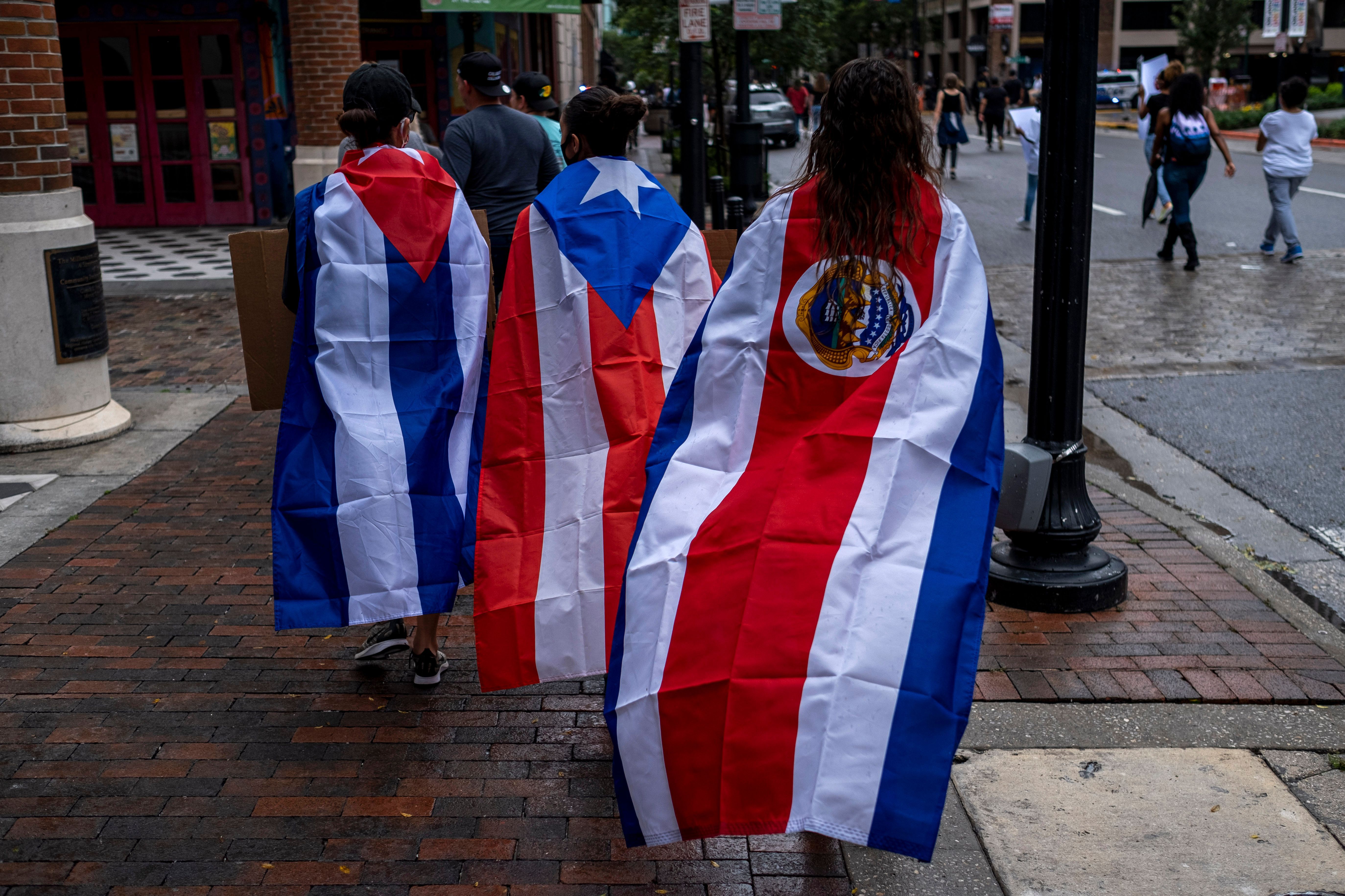 Protesters wear Cuban, Puerto Rican and Costa Rican flags during a rally in response to the death of George Floyd in police custody in Minneapolis, in Orlando, Florida.