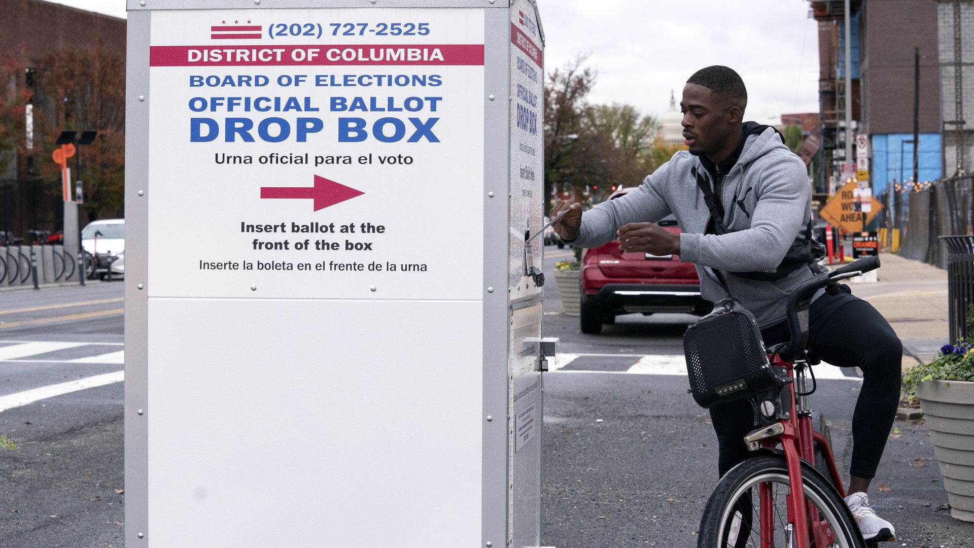 A man is dropping his ballot into the elections drop box