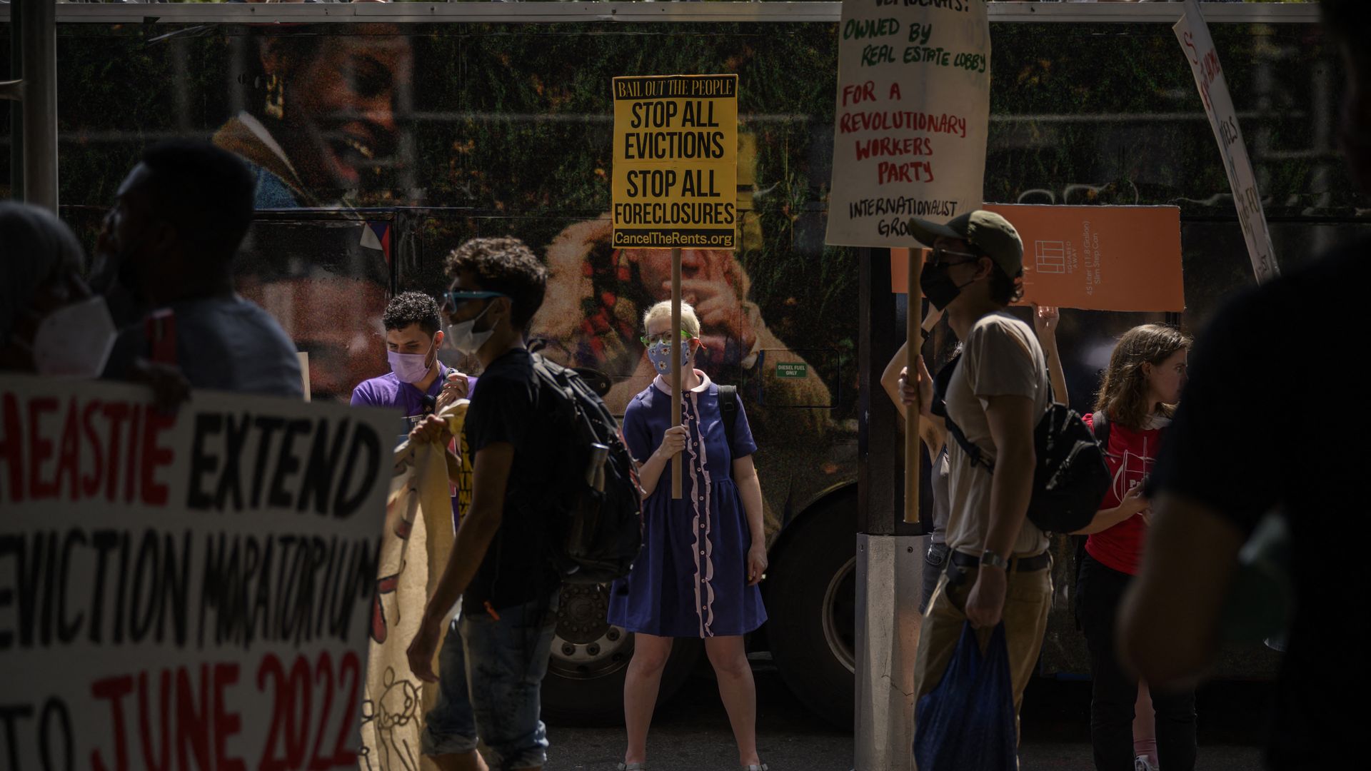 Photo of protesters holding signs demanding cancellation of rent on an outdoor sidewalk