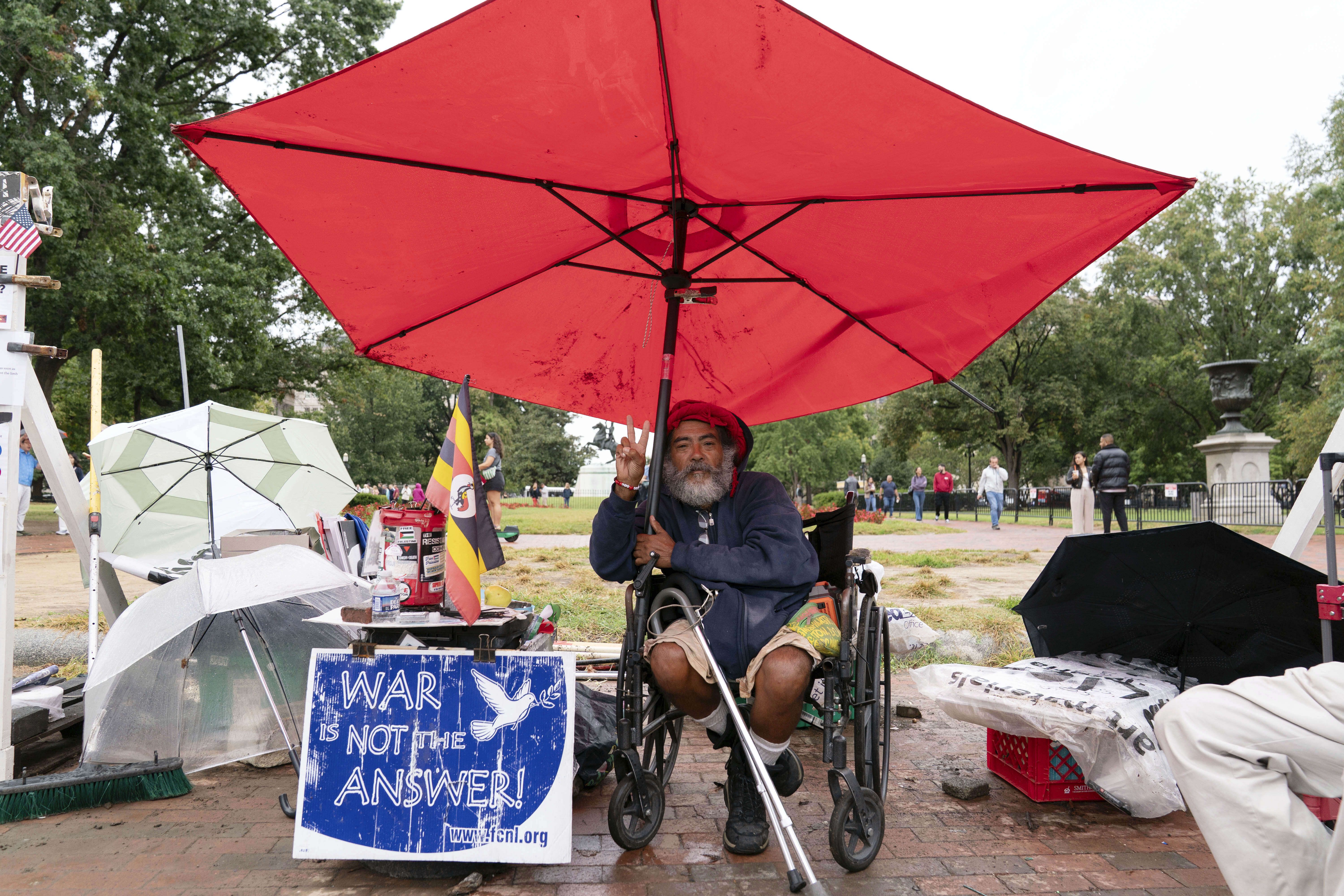 Philipos Melaku-Bello flashes the V sign during Peace Vigil in Lafayette Park across from the White House on Sunday.