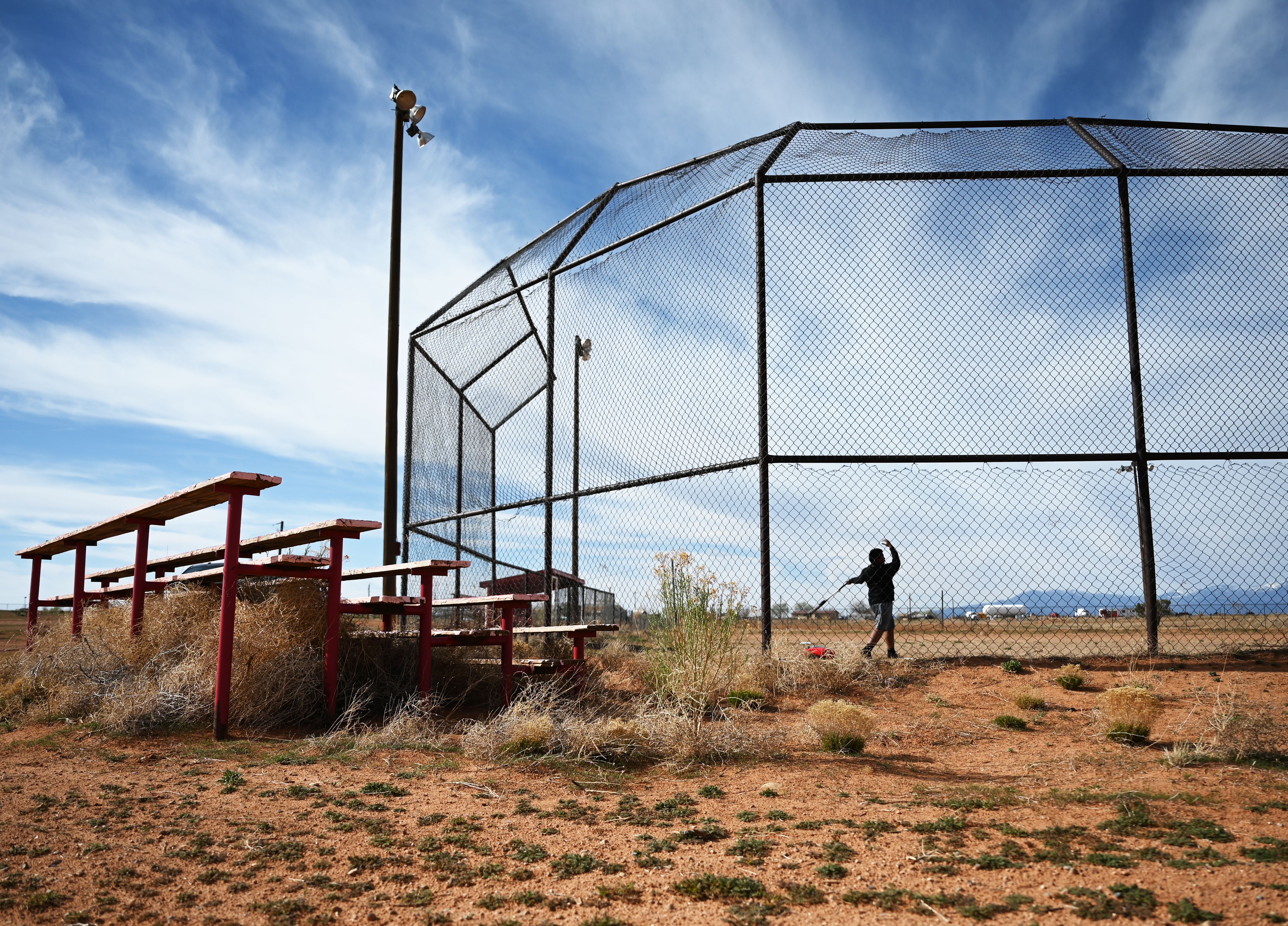 umbleweeds pushed by the winds during the drought gather under wooden bleachers as Trai Bass, 12, hits a baseball he tossed into the air while he plays alone at the baseball field on Ute Mountain Ute Tribe Reservation on April 4, 2022 in White Mesa, Utah. 