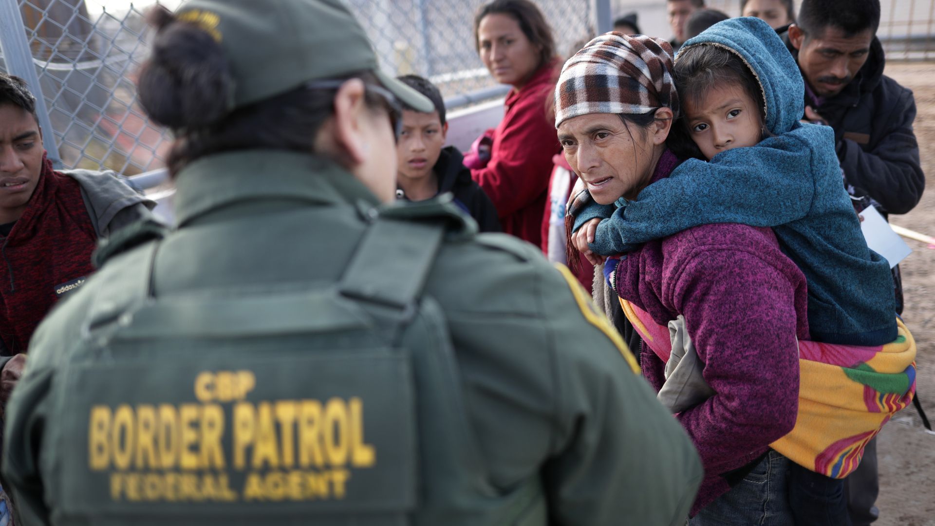Border Patrol agent takes Central American immigrants into custody. 