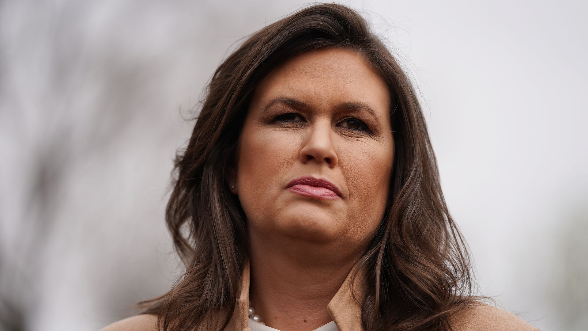 In this image, Sarah Sanders stands and looks straight ahead.