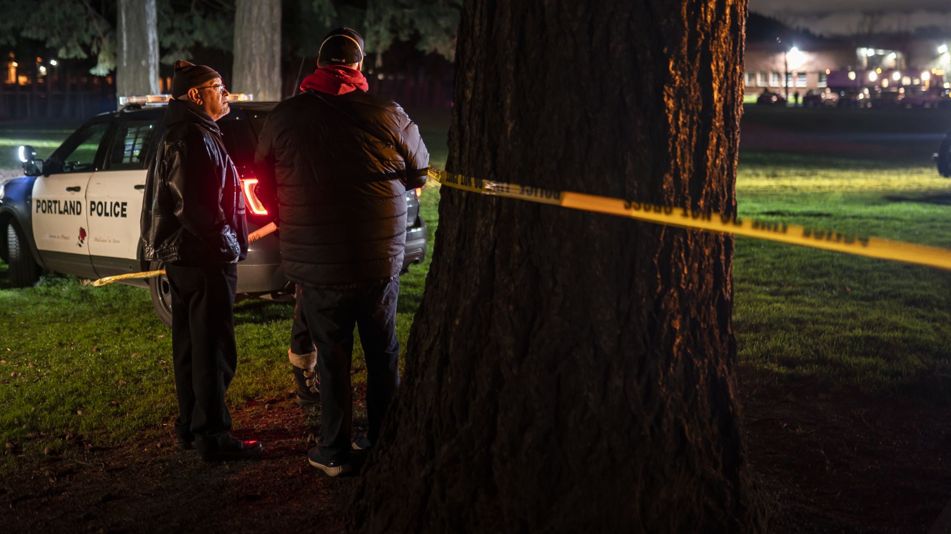 Neighbors watch as Portland police investigate a shooting that took place during a protest for Amir Locke, which officials said left one dead and five others injured, on February 19.