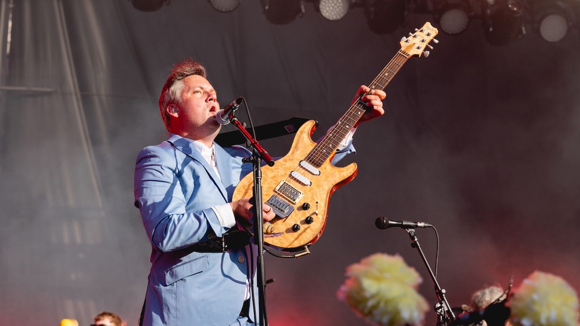 A photo of a person holding a guitar.