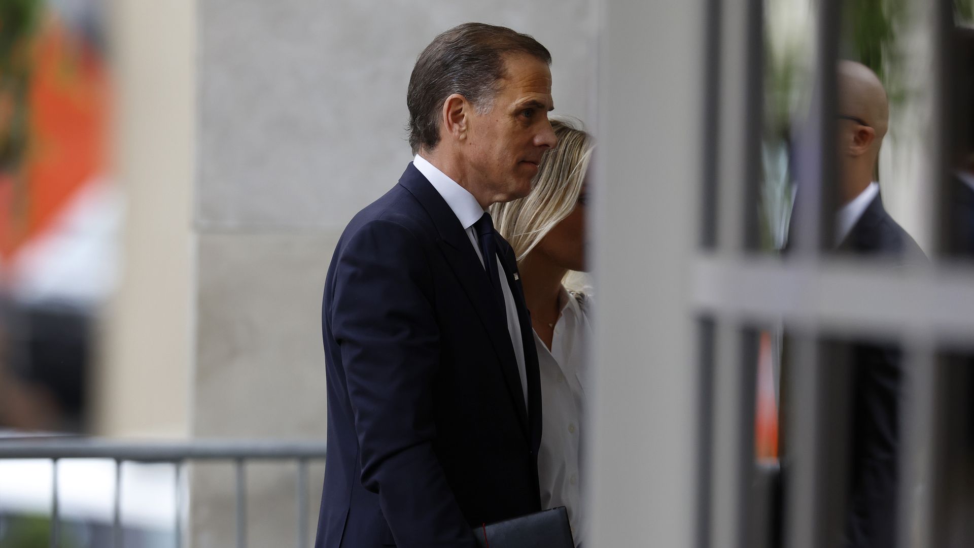 Hunter Biden, wearing a blue suit, walking into a building.