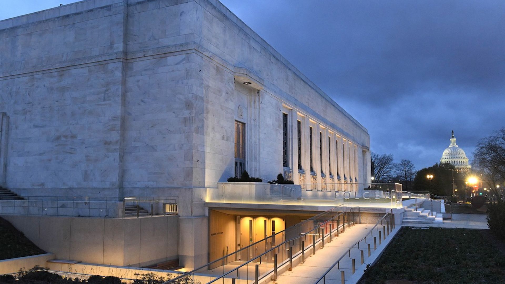 The Folger Shakespeare Library at night with the Capitol Building in the background 