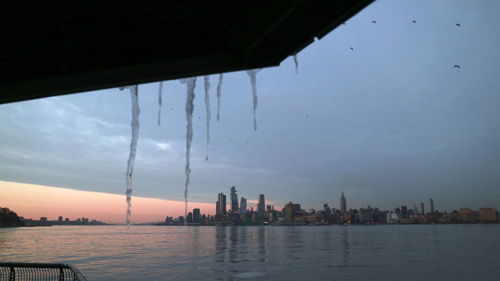 Icicles hang in front of Hudson Yards and the Empire State Building at sunset in New York City 