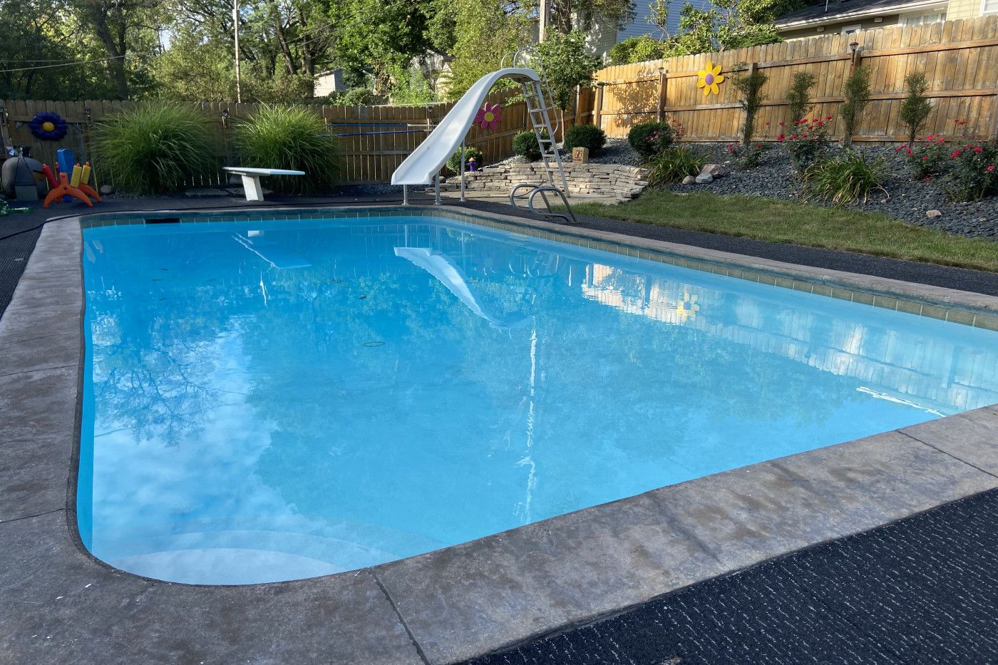 backyard pool with slide and diving board