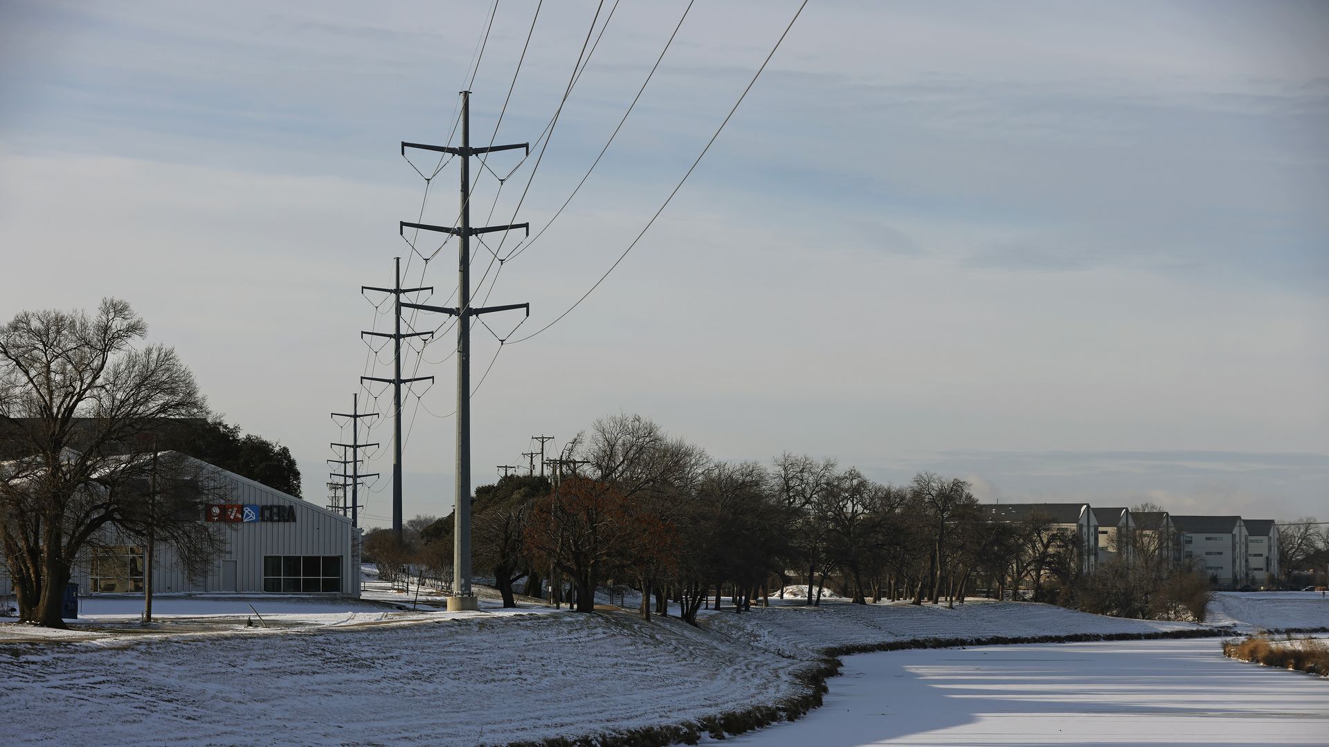 Transmission towers support power lines above the frozen over Clear Fork of the Trinity River after a snow storm on February 16, 2021 in Fort Worth, Texas.