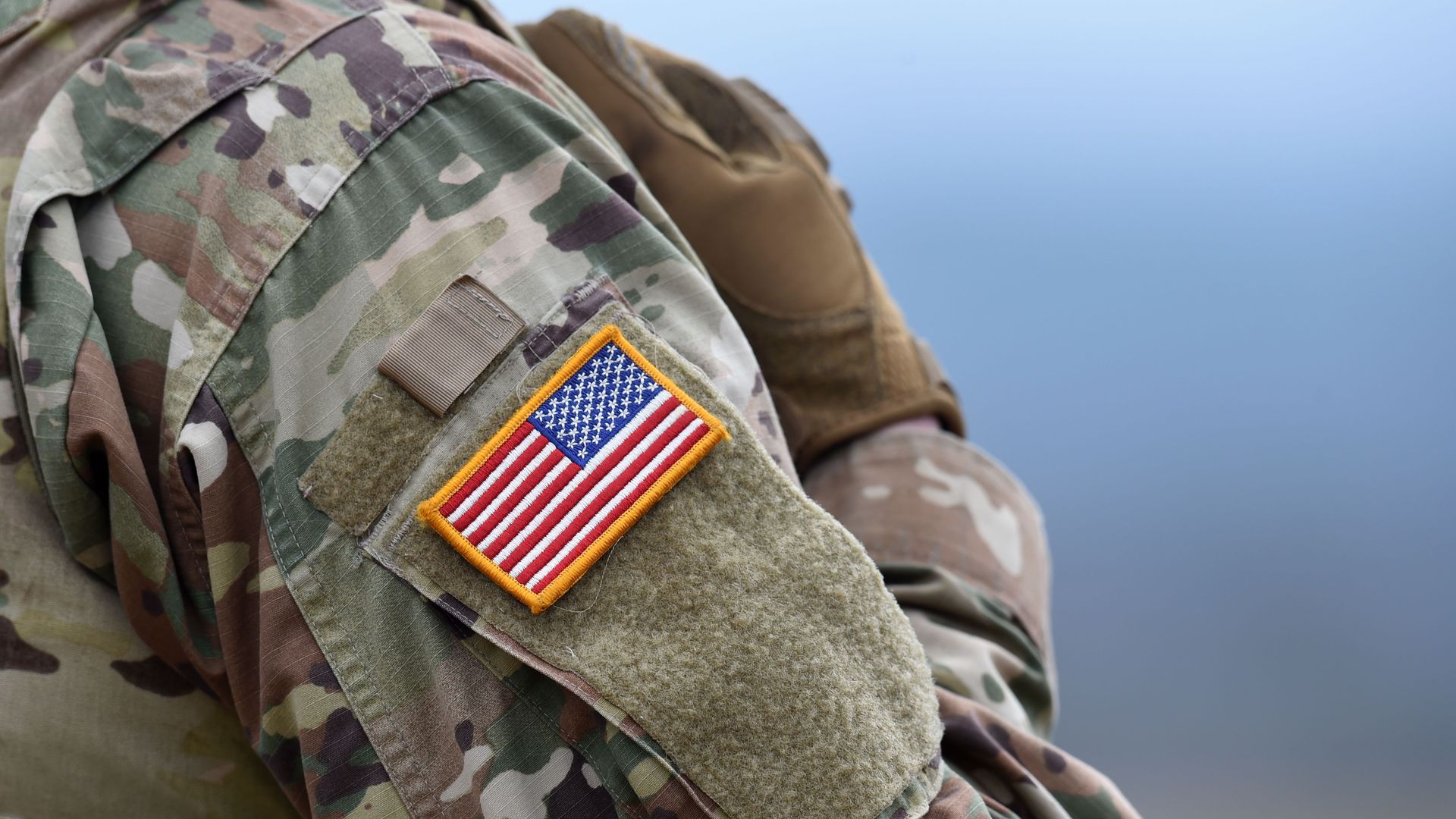 A US flag is pictured on a soldier's uniform