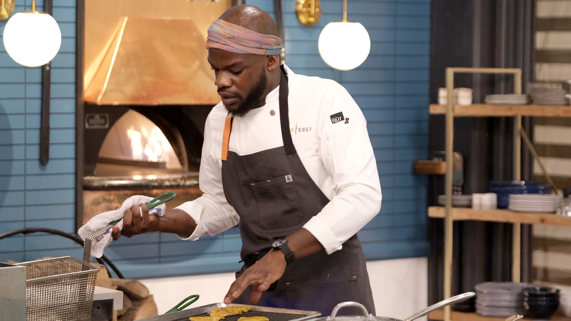 Chef Charly Pierre settles a basket back into a fryer.