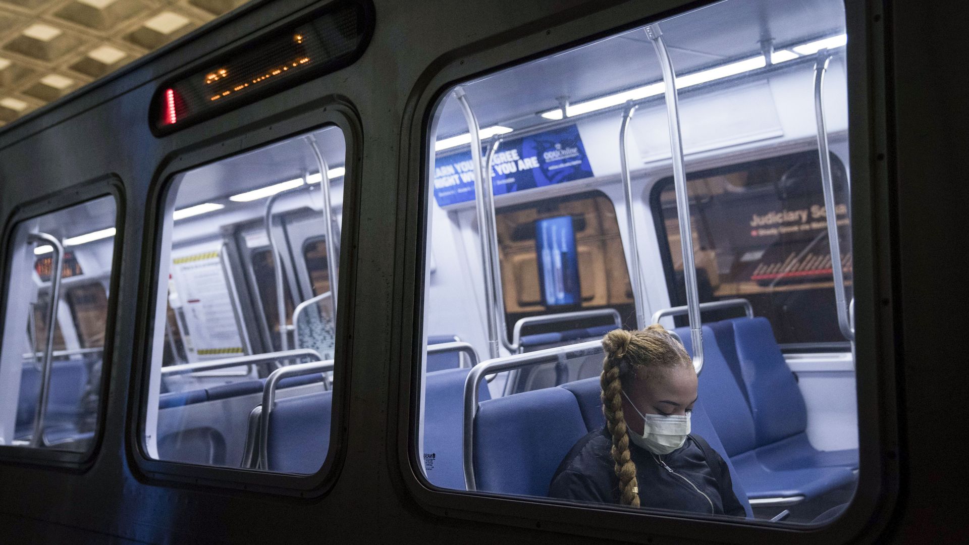 A person wearing a mask on a Metro car.