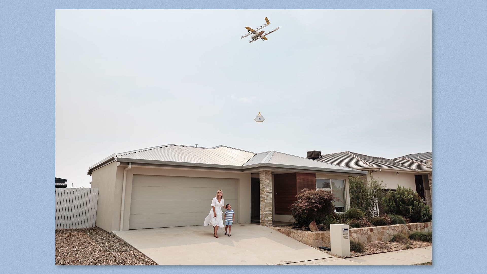 Image of a Wing drone delivering a package to a family's driveway in Logan, Australia