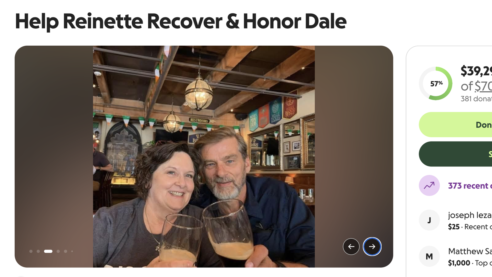 Two smiling adults take a selfie in a cozy restaurant, raising beer glasses. Warm lighting, exposed wooden beams, and colorful banners decorate the background.