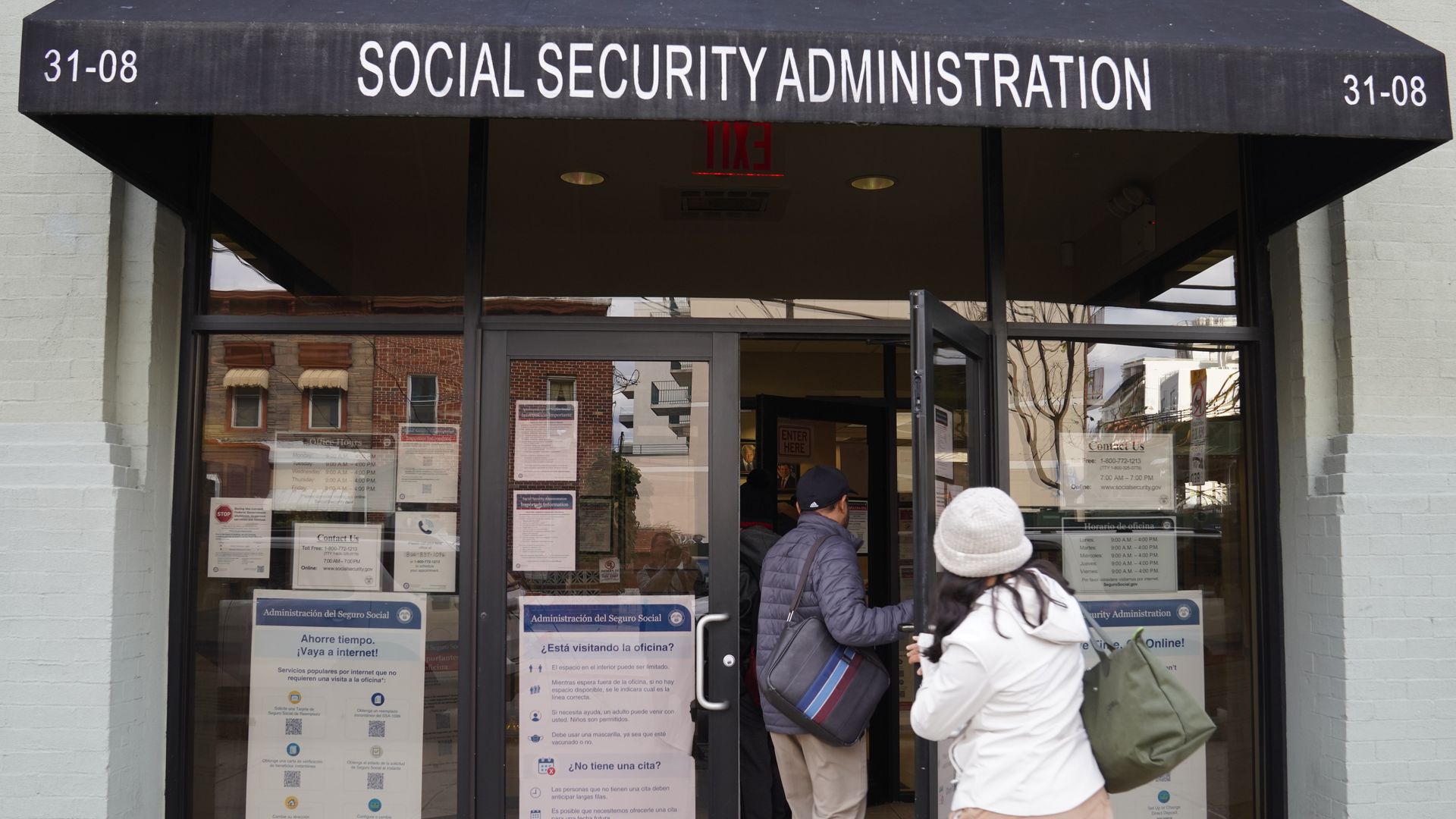 People enter an office under an awning that says Social Security Administration.