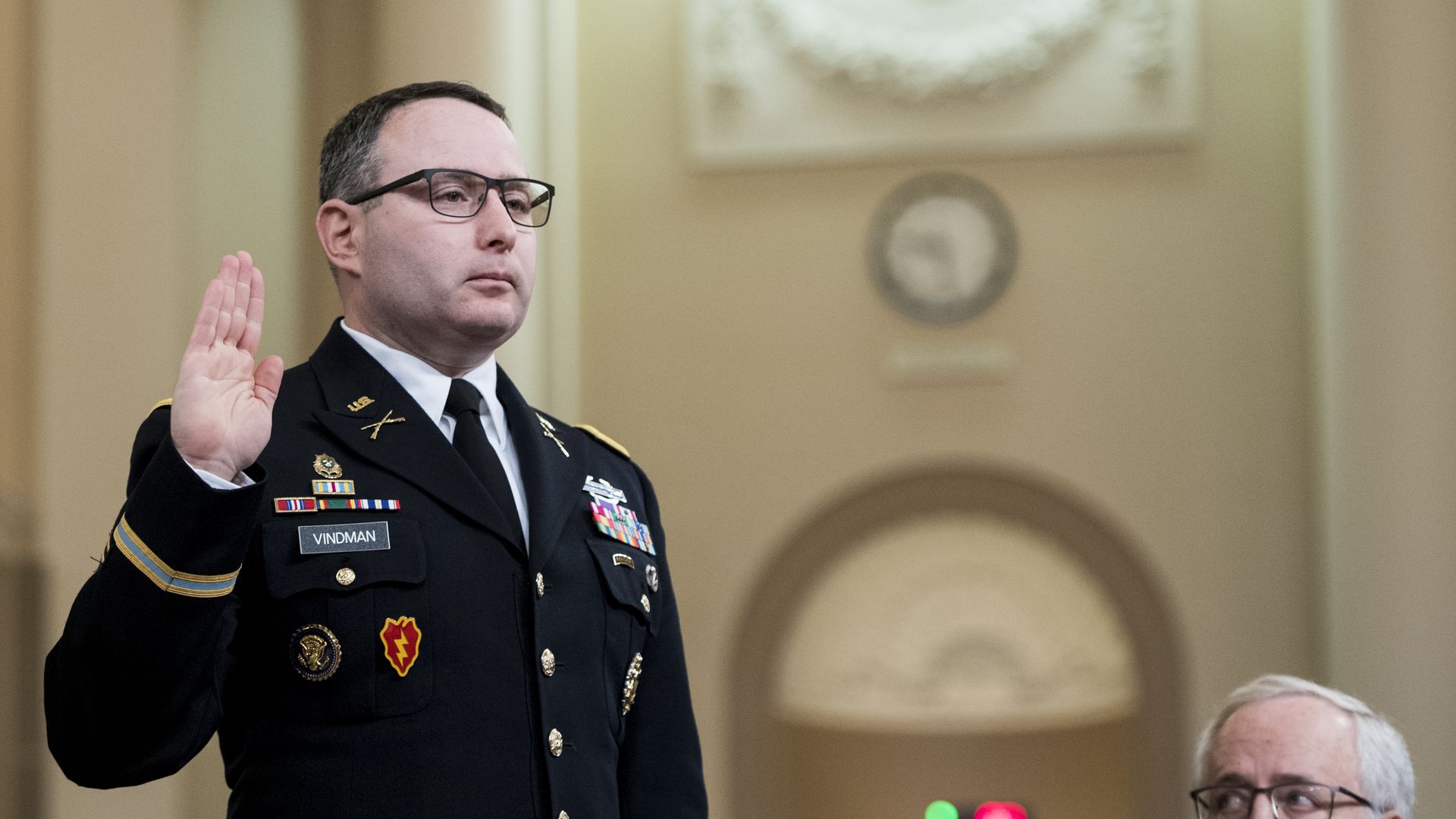Picture of Alexander Vindman wearing military uniform with his right hand raised as he is sworn in before testifying in the Trump impeachment hearings.