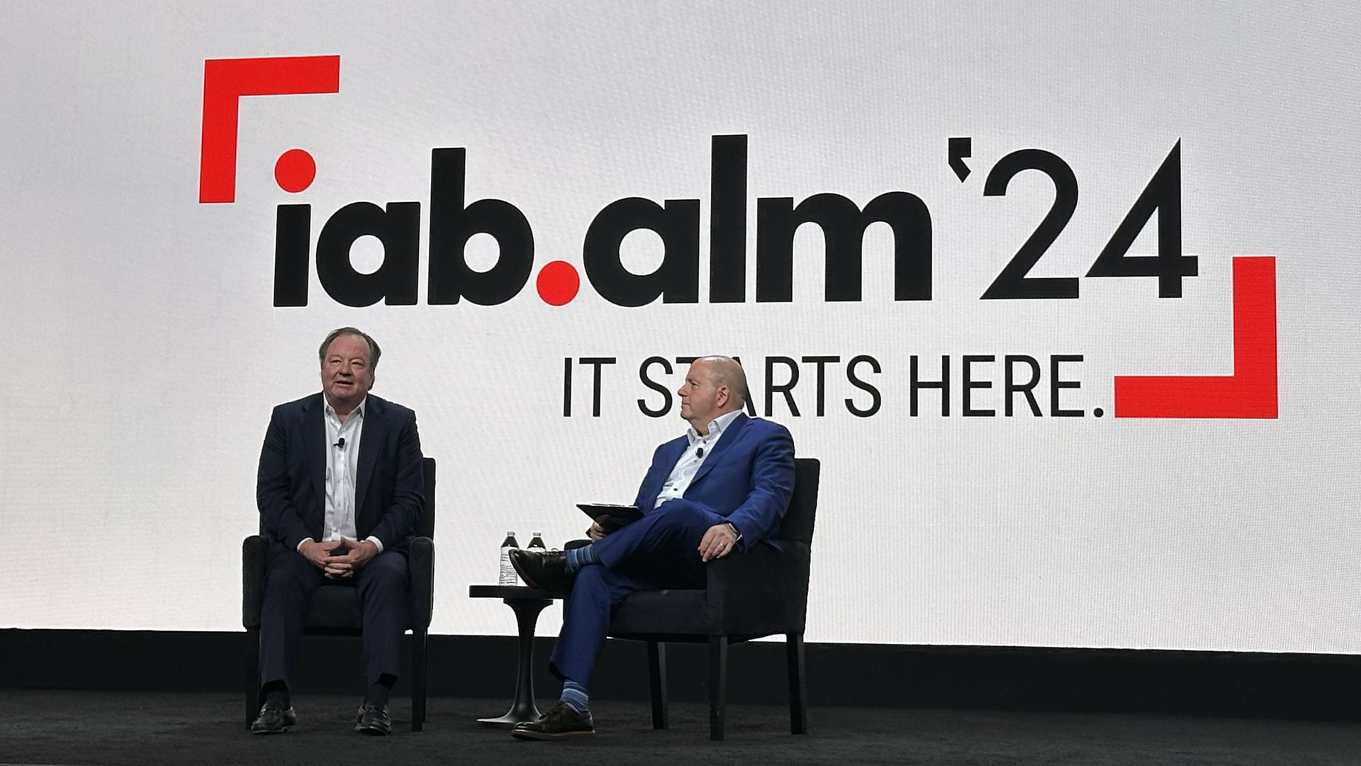 Paramount Global CEO Bob Bakish and IAB CEO David Cohen sitting on chairs on a stage with IAB AM '24 It Starts Here in the background